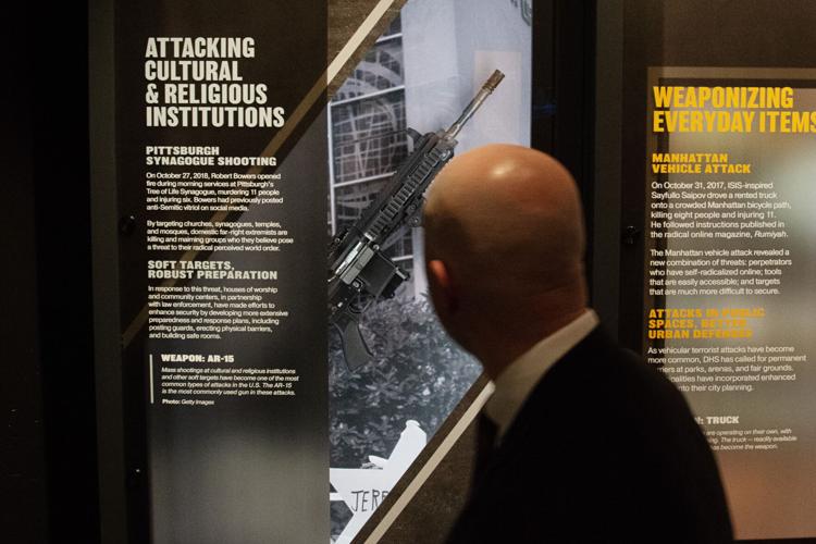 A Counterterrorism Education Learning Lab (CELL) museum visitor walks by an AR-15