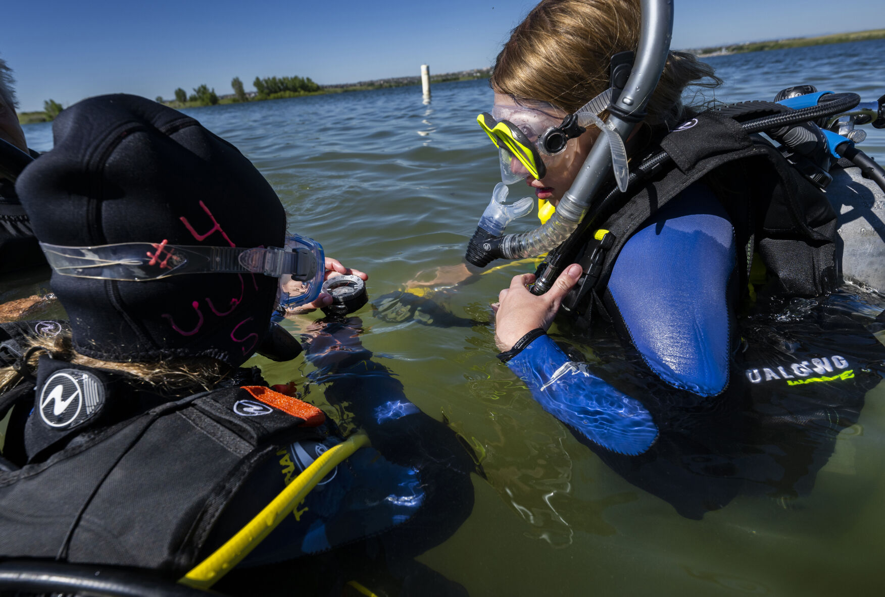 Avery Beebe, 10, left, and her sister, Autumn Beebe, 12, practice using a compass Sunday, July 16, 2023, during a beginners diving class at Aurora Reservoir near Denver. (The Gazette, Christian Murdock) (Christian Murdock/The Gazette)