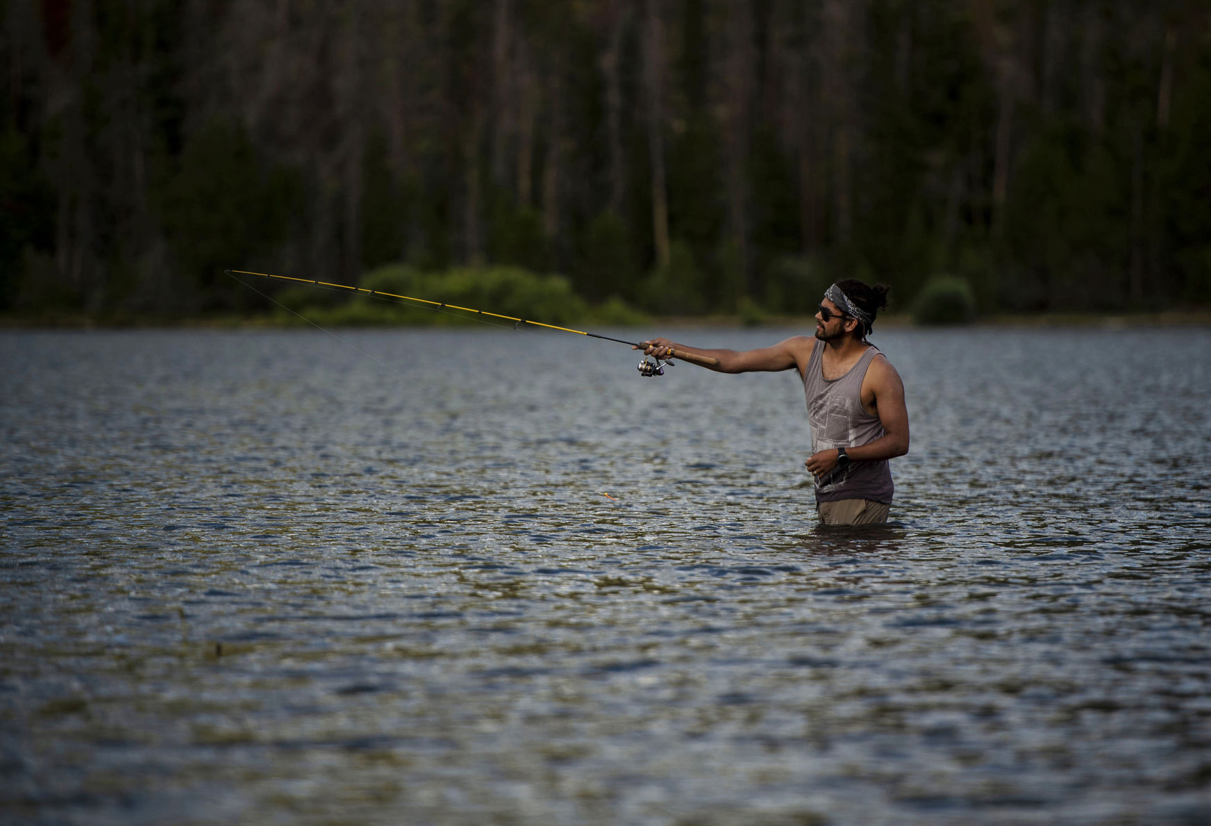 Eric Burgos wades in the water while fishing at Dillon Reservoir recreation site in Summit County on Saturday, August 3, 2019. Dillon Reservoir is currently 100 percent full, according to Todd Hartman with Denver Water. Hartman states this time last year the reservoir was down, 91 percent full. Dillon Reservoir was not filled until July this year, in contrast to last year which was filled at the end of May. Colorado had strong snow pack in the high country and a long run off season.