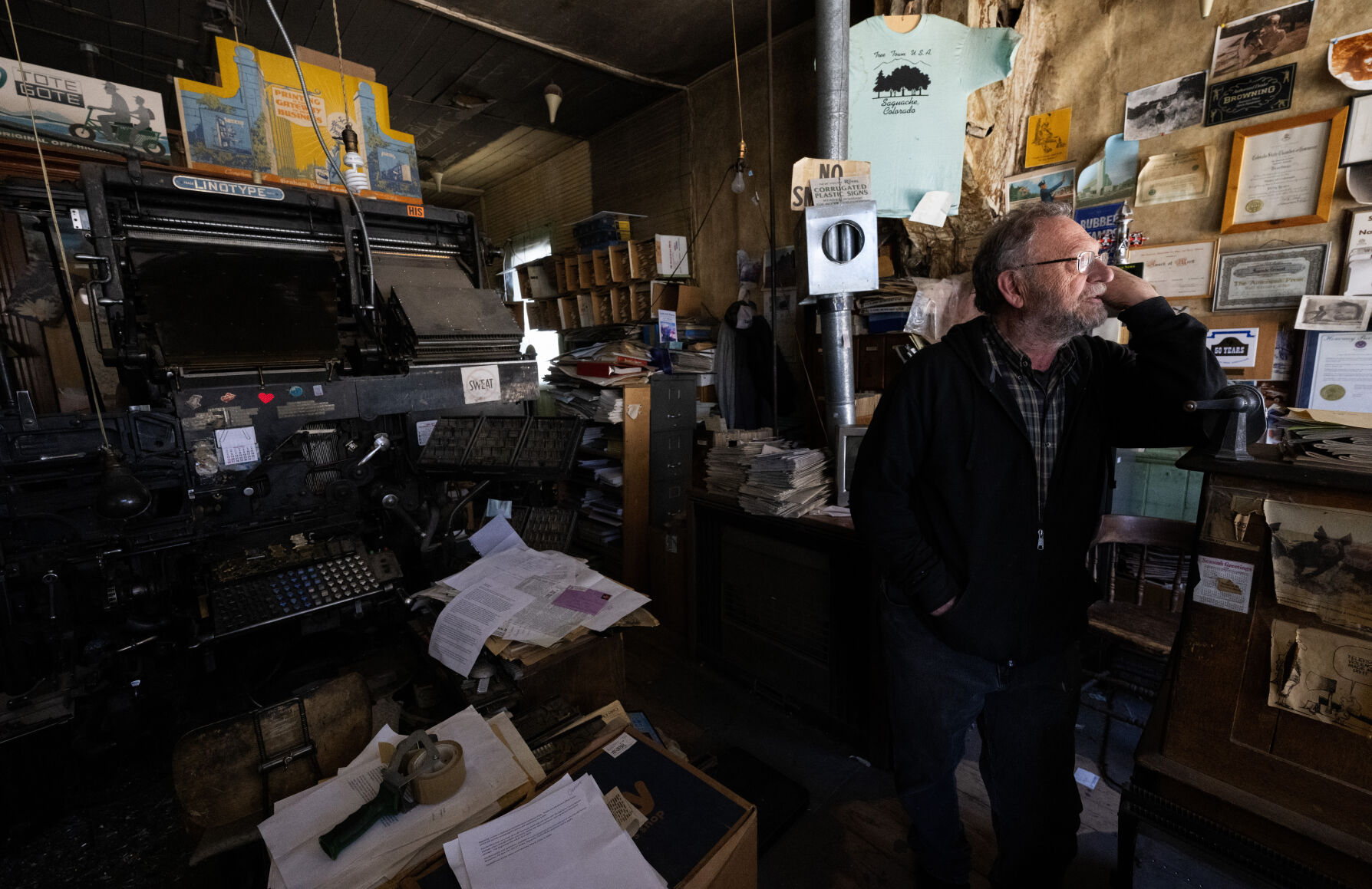 Dean Coombs, 72, looks out the window Thursday, May 8, 2024, in the newpaper office of the Saguache Crescent in Saguache, Colo. His family has been running the small-town newspaper since 1917. The Crescent is believed to be the last linotype-made newspaper in the country, possibly the world. (The Gazette, Christian Murdock) (Christian Murdock/The Gazette)
