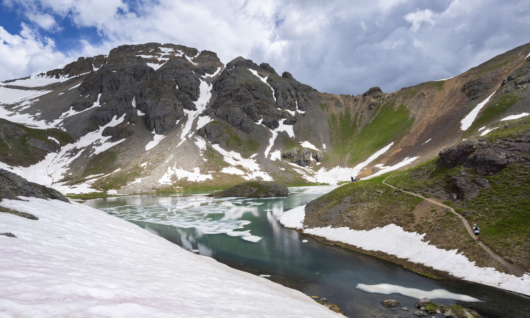 A hiker reaches Island Lake as the snow still surrounds it at an elevation more than 12,000 feet in the San Juan Mountains Monday, July 10, 2023. The hike from the South Mineral Creek trailhead outside Silverton is about 9 miles round trip via Ice Lake. (The Gazette, Christian Murdock) (Christian Murdock/The Gazette)