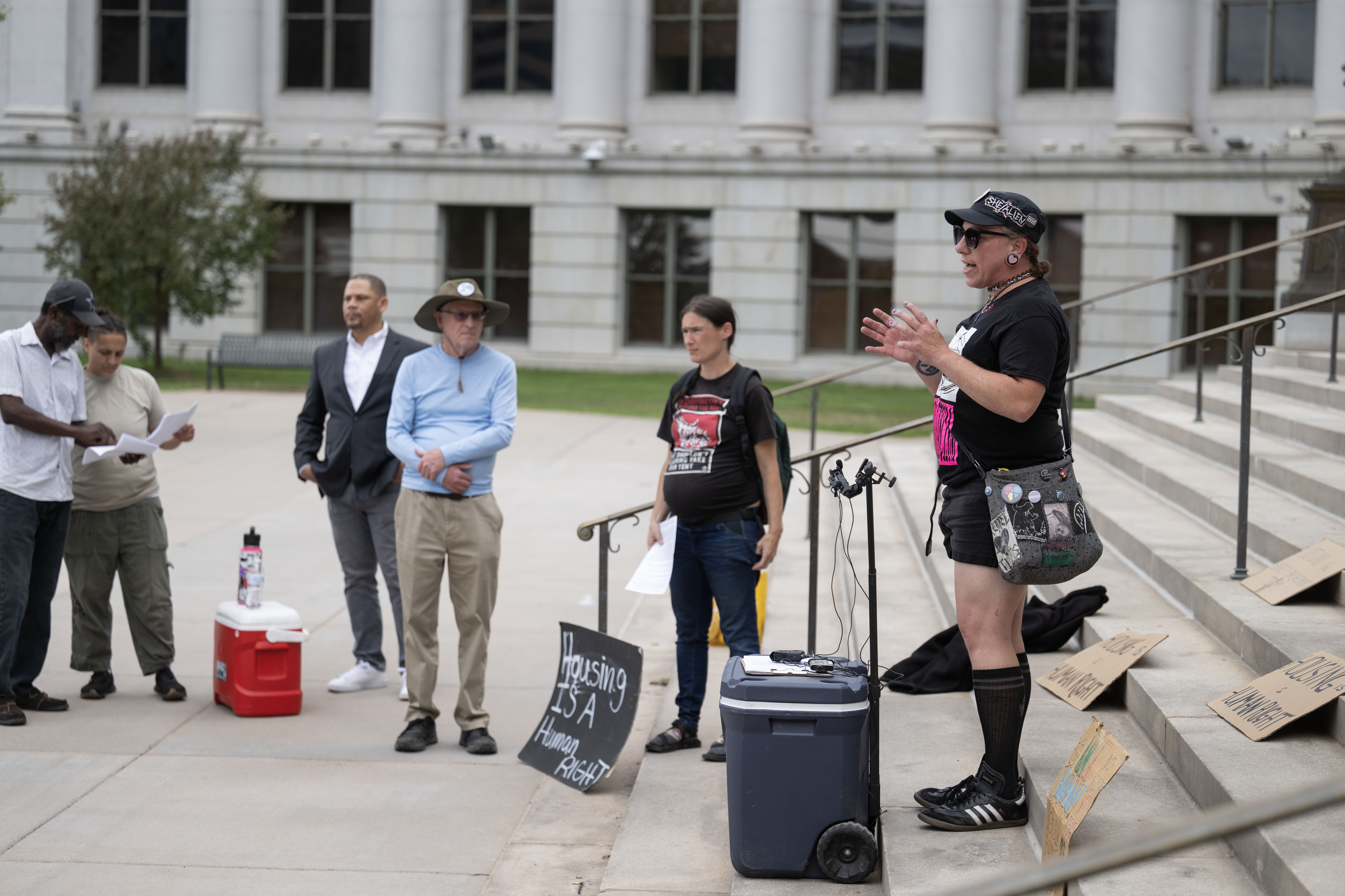 Ana-Lilith Miller, with the Housekeys Action Network Denver, presents statistics of police records showing an increase in anti-houseless law enforcement in Denver from January to March of 2024 during a protest on the steps of the Denver City and County Building on Monday, June 3, 2024. (Stephen Swofford, Denver Gazette) (Stephen Swofford The Gazette)