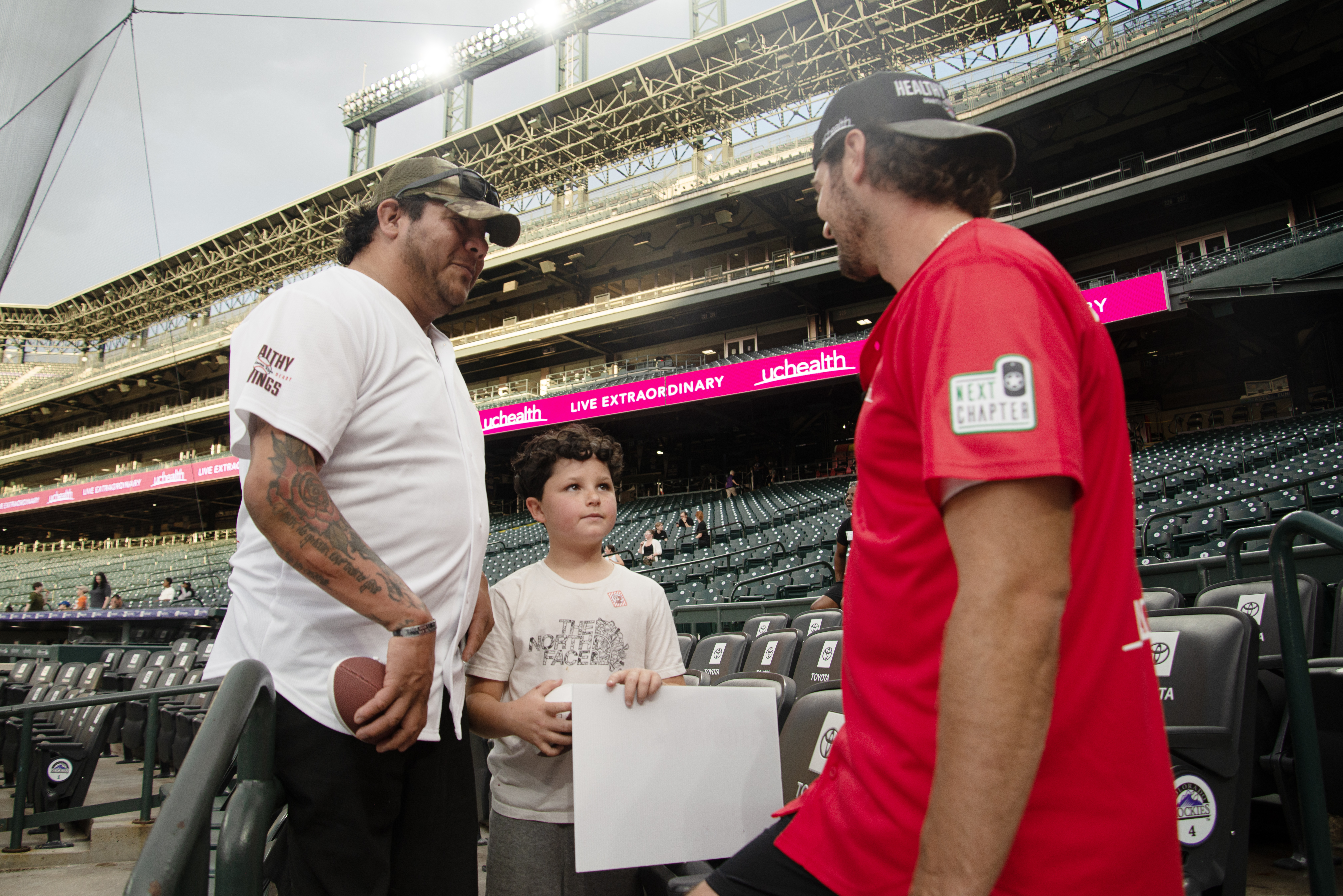 Denver Broncos quarterback Jarrett Stidham, right, signs autographs for Richard Sanchez and his stepson Jack during the UCHealth 'Healthy Swings' home run derby for charity at Coors Field on Wednesday, June 12, 2024. Sanchez, an Army veteran, was one of several in attendance for the charitable event, which raised money for Next Chapter, a Colorado-based veterans charity focusing on helping veterans transition to civilian life. (TomHellauerMultimedia Producertom.hellauer@denvergazette.comhttps://denvergazette.com/content/tncms/avatars/f/9e/622/f9e6228a-3b6b-11ed-bf10-fbb71fa8e421.f54b911252c540f1d61709edc4727a39.png)