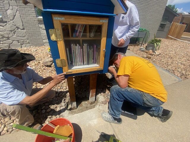 Krishna Sinha, Chaeyun Kim and Rush Schnel, (in yellow shirt) install Little Free Library in front of Dacono's Pride of the Glens Community Center - Orgullo de los Glens - on Saturday, June 8, 2024. (Carol McKinley)