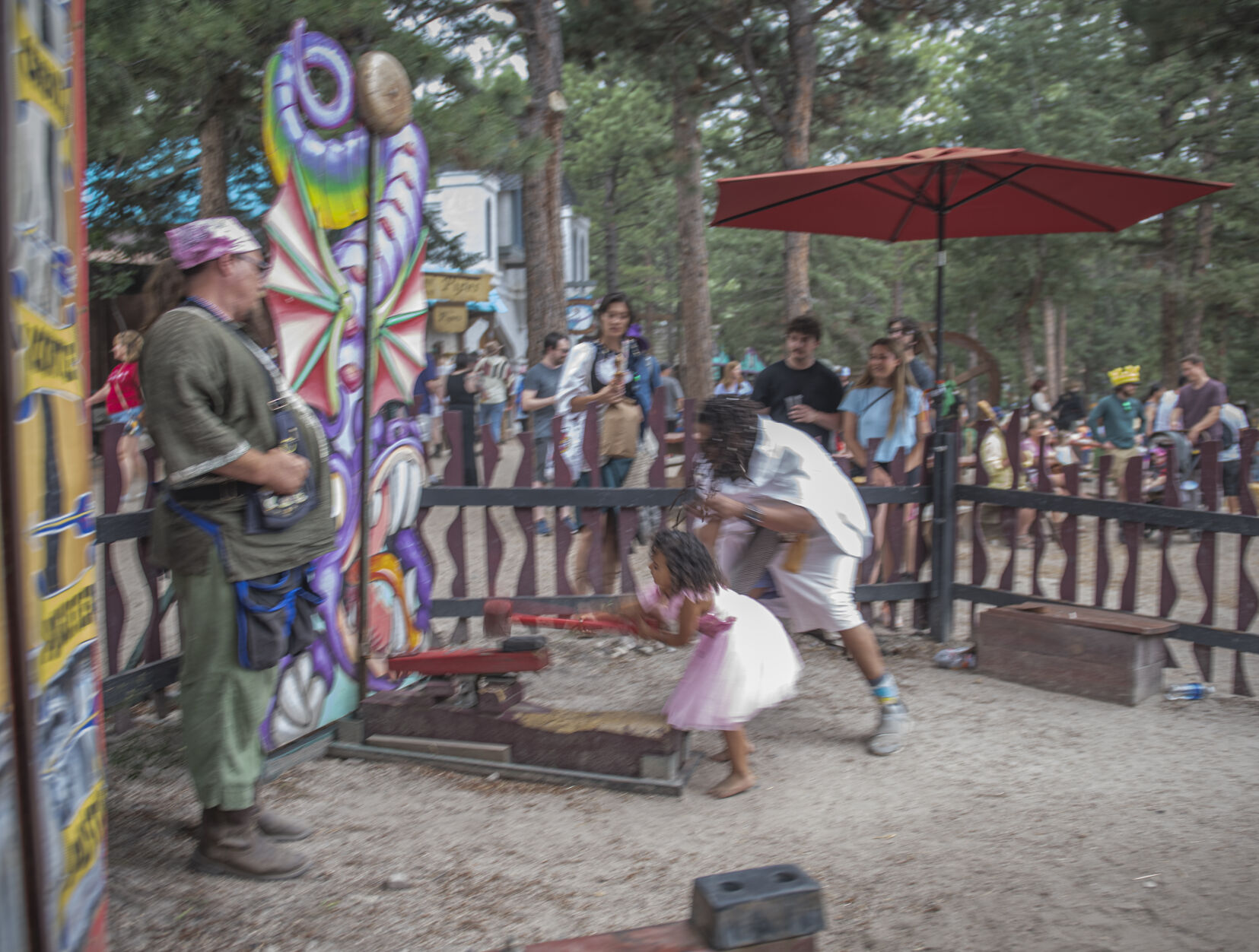 FILE PHOTO: Kirstin Jung of Inglewood watches with her son James as her partner Clarence Byrd helps her daughter Jasmine hit the target at the high striker during the Colorado Renaissance Festival in Colorado Springs, Co., on Saturday, July 29, 2023. (Gabi Broekema/The Gazette)