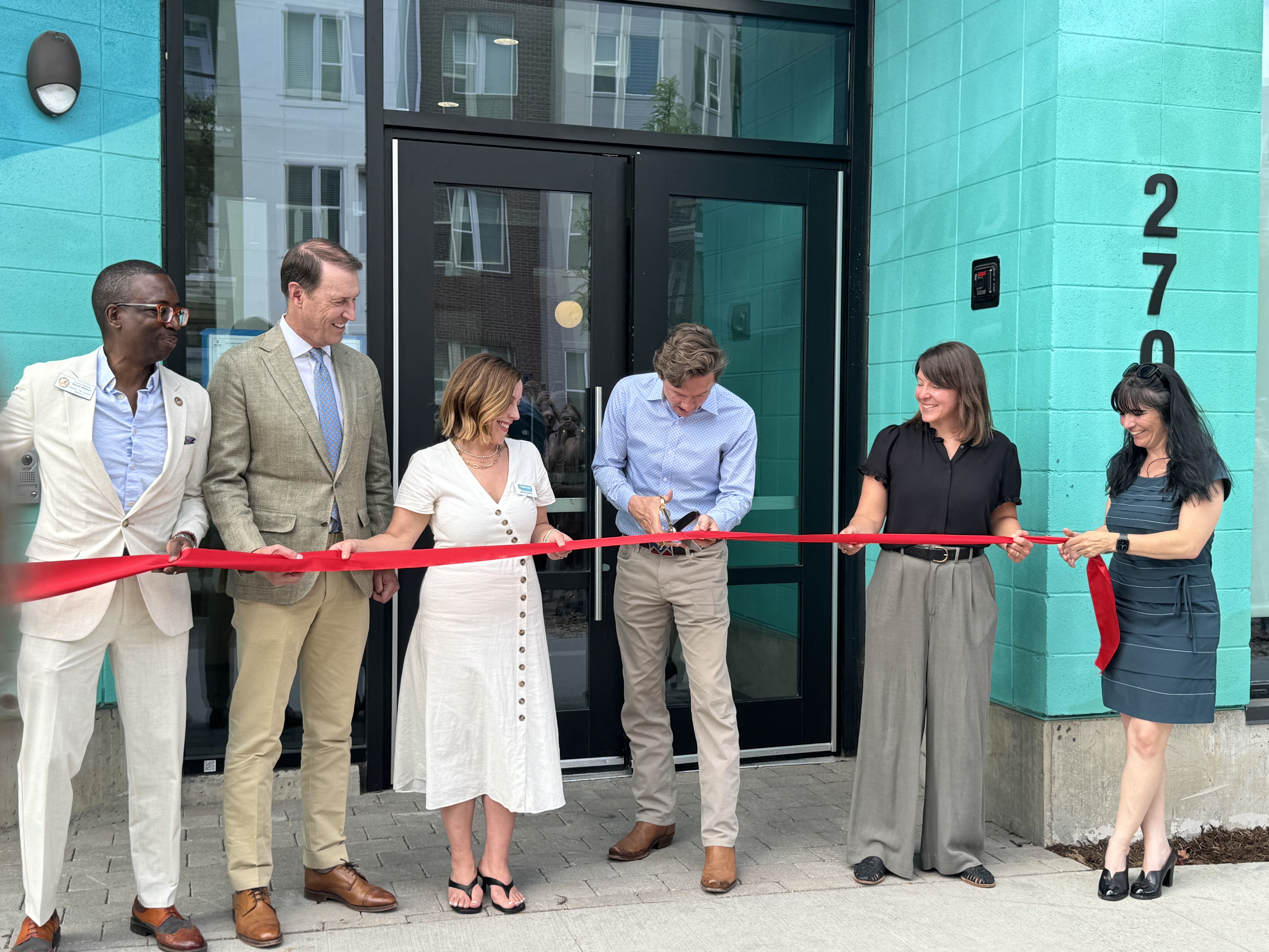 Mayor Mike Johnston (center) cuts a ribbon, officially opening the Nest56 housing development. Nest56 is geared toward providing supportive housing for at risk youth aged 18-24 in Denver. (Courtesy photo, Denver Mayor's Office)