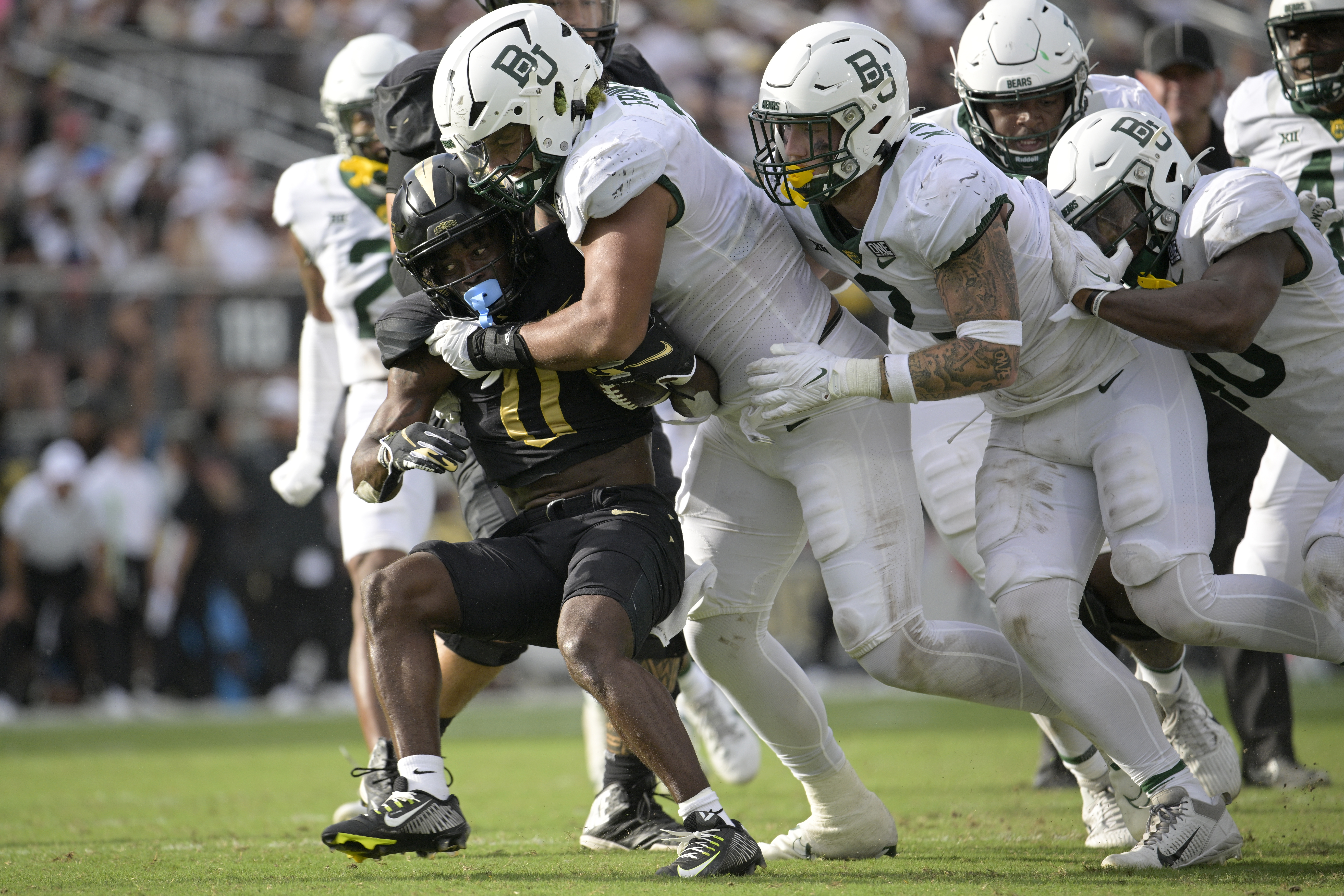 Central Florida running back Johnny Richardson (0) is tackled by Baylor defensive lineman TJ Franklin as linebacker Matt Jones (2) and linebacker Mike Smith Jr. (40), right, help during the second half of an NCAA football game on Saturday, Sept. 30, 2023, in Orlando, Fla. (AP Photo/Phelan M. Ebenhack) (Phelan M. Ebenhack)