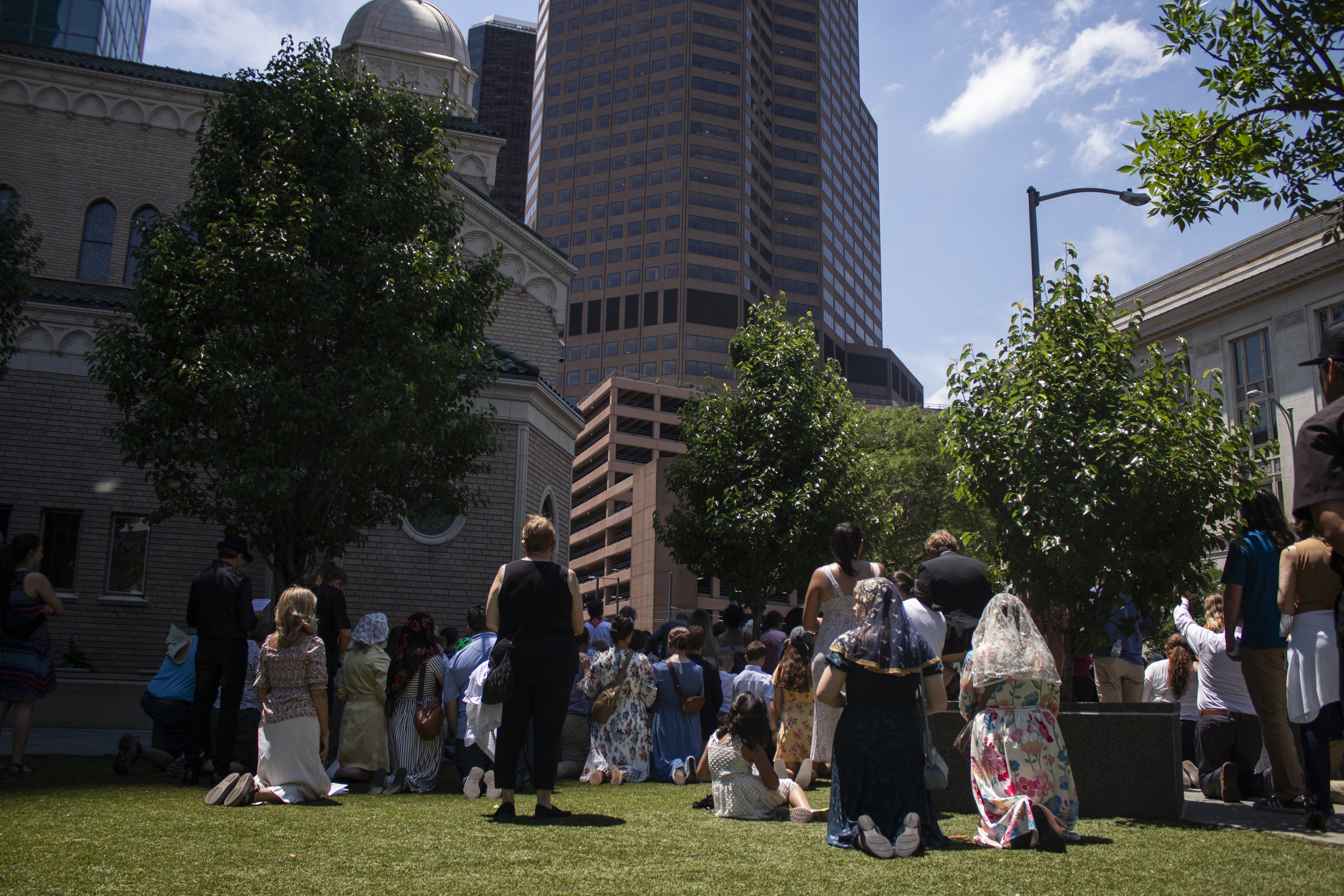 Worshipers kneeled outside Holy Ghost Church at the end of the Eucharistic procession around downtown Denver on Sunday, June 9, 2024. (Bernadette Berdychowski / Denver Gazette)