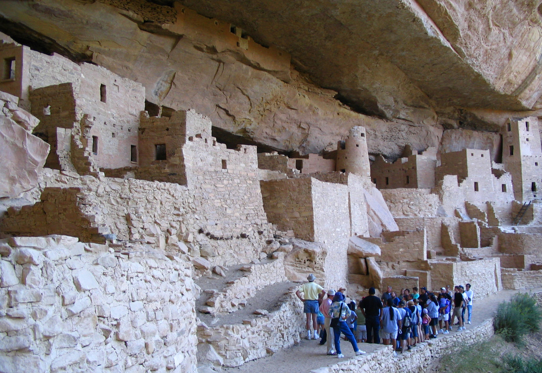 FILE - In this Aug. 27, 2005 file photo, visitors tour Cliff Palace, an ancient cliff dwelling in Mesa Verde National Park, Colo. Researchers say they have new evidence that ancestral Pueblo people who disappeared from the Mesa Verde cliff dwellings of southwestern Colorado 700 years ago migrated to what is now New Mexico. DNA from the bones of domesticated turkeys. The turkey DNA shows Native American people in the Rio Grande Valley of northern New Mexico raised and ate the same genetic strain of bird as the Mesa Verde people, and that the turkeys arrived in New Mexico about the same time Mesa Verde was abandoned, the researchers said. (AP Photo/Beth J. Harpaz,File) (BETH J. HARPAZ)