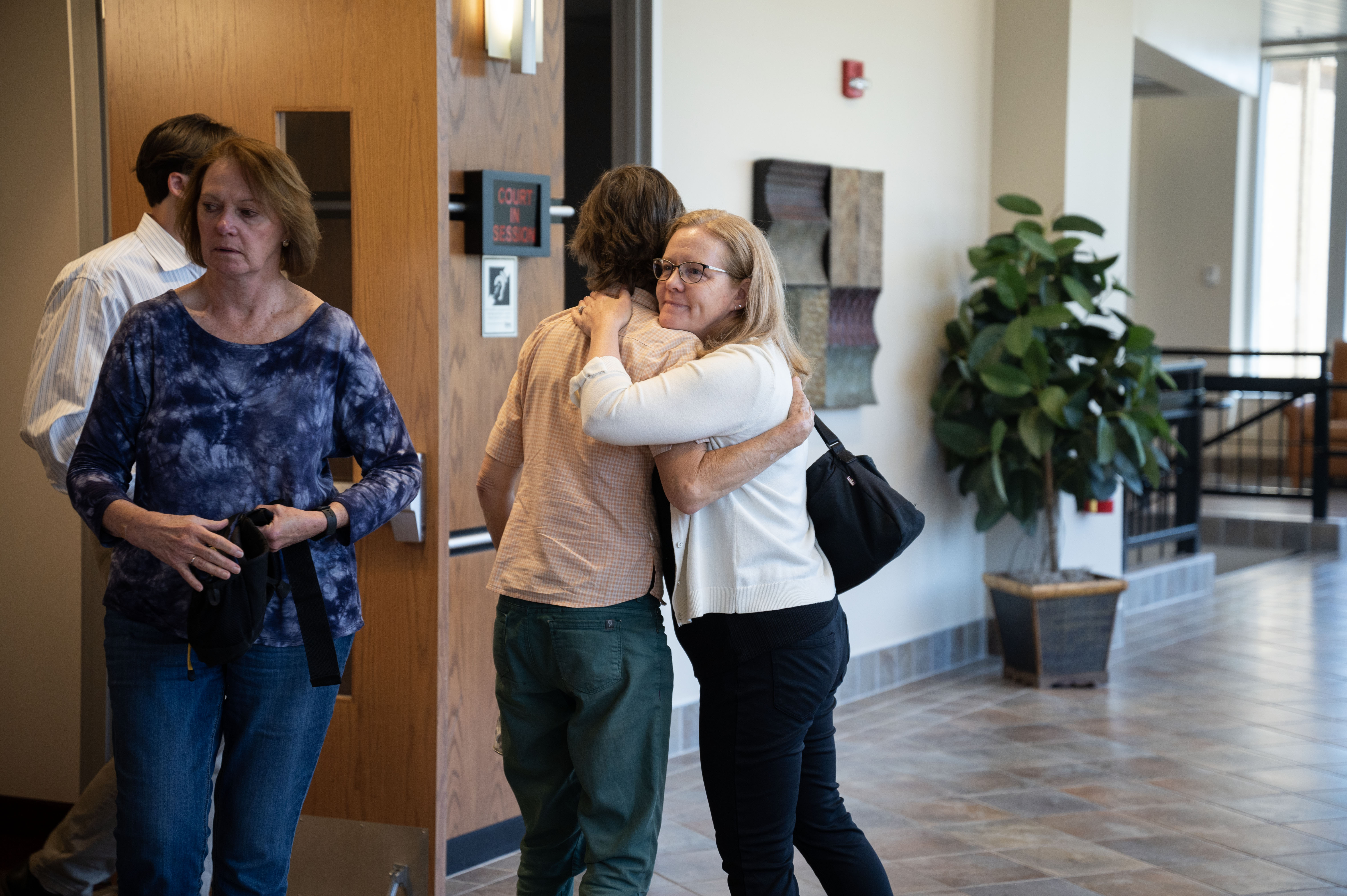 Family members of three murder victims hug one another outside the courtroom after Garrett Coughlin pleaded guilty to second-degree murder for a triple homicide. Coughlin was sentenced to 42 years with the possibility of parole after 24 years. (Stephen Swofford, The Gazette)