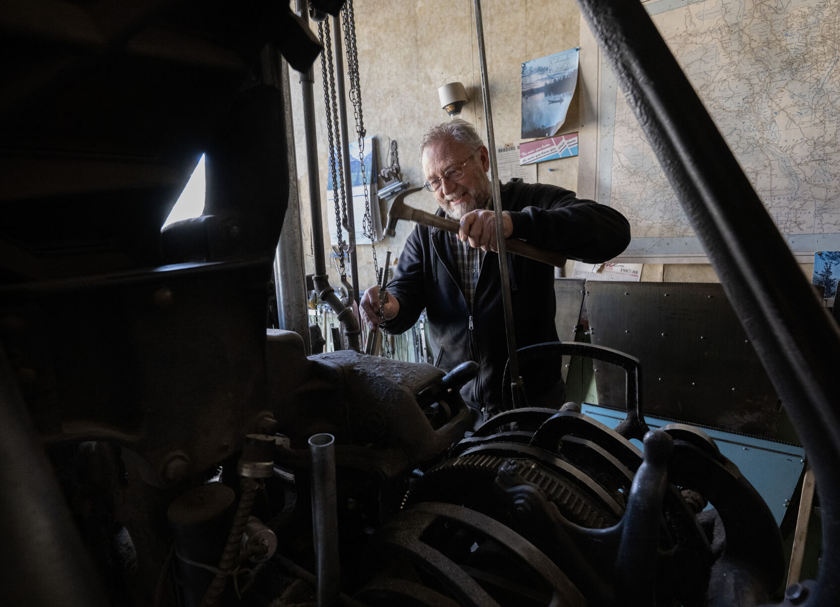 Dean Coombs, 72, hammers a solid piece of lead so it melts while operating his 1920 model Linotype machine Thursday, May 8, 2024, as he produces the next edition of the Saguache Crescent in Saguache, Colo. (The Gazette, Christian Murdock) (Christian Murdock/The Gazette)