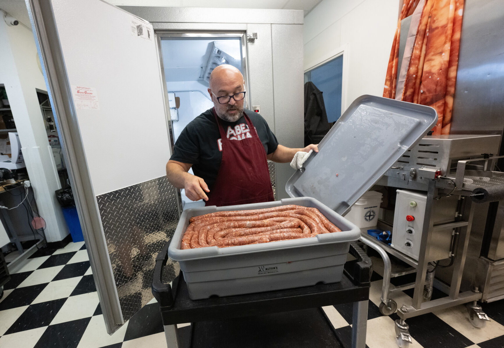 Vince Gagliano pulls the hot Pueblo Chile Italian Sausage out of the cooler to be cut into links this month at Gagliano’s Italian Market & Deli meat-packing facility down the street from the market in Pueblo. (Christian Murdock, The Gazette)