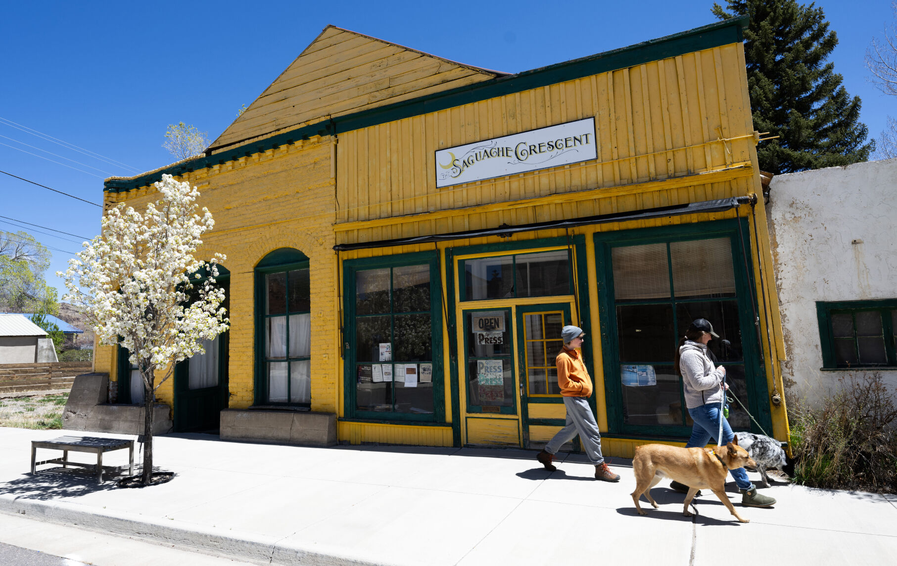 Pedestrians walk past the 1870s newpaper office of the Saguache Crescent Thursday, May 8, 2024, in Saguache, Colo. Dean Coombs' family has been running the small-town newspaper since 1917. The Crescent is believed to be the last linotype-made newspaper in the country, possibly the world. (The Gazette, Christian Murdock) (Christian Murdock/The Gazette)