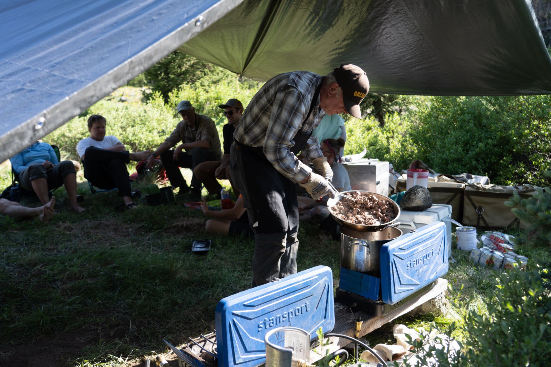 Weeklong Volunteers for Outdoor Colorado project in 2021 in the Weminuche Wilderness. Volunteer Crew chef Tim Zvada hard at work in the camp kitchen fixing up dinner for the crew. Photo by volunteer photographer Nicholas Guthrie