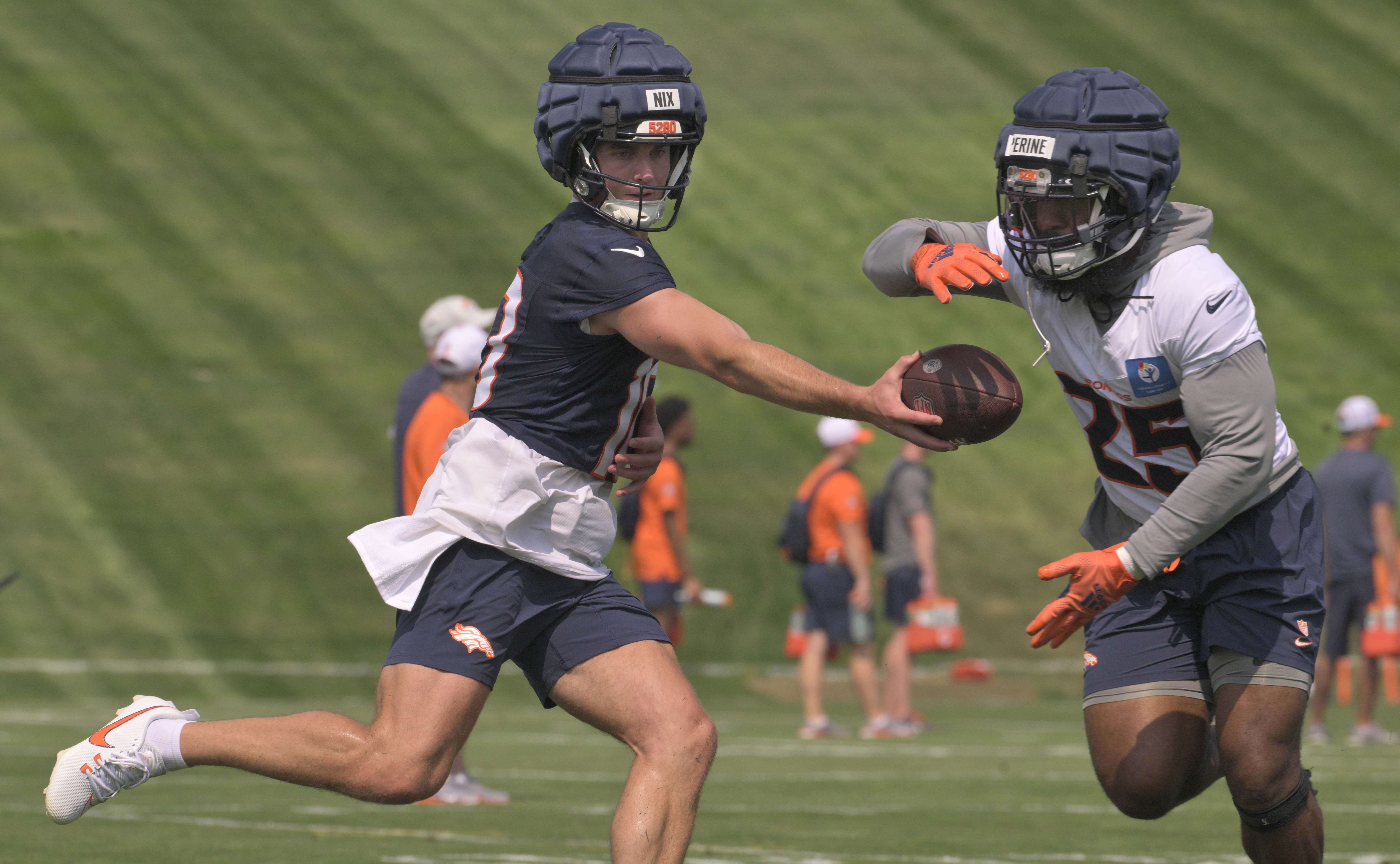 Broncos quarterback Bo Nix hands off the ball to running back Samaje Perine during practice at the Denver Broncos training center on Wednesday, July 24, 2024. (Jerilee Bennett The Gazette)
