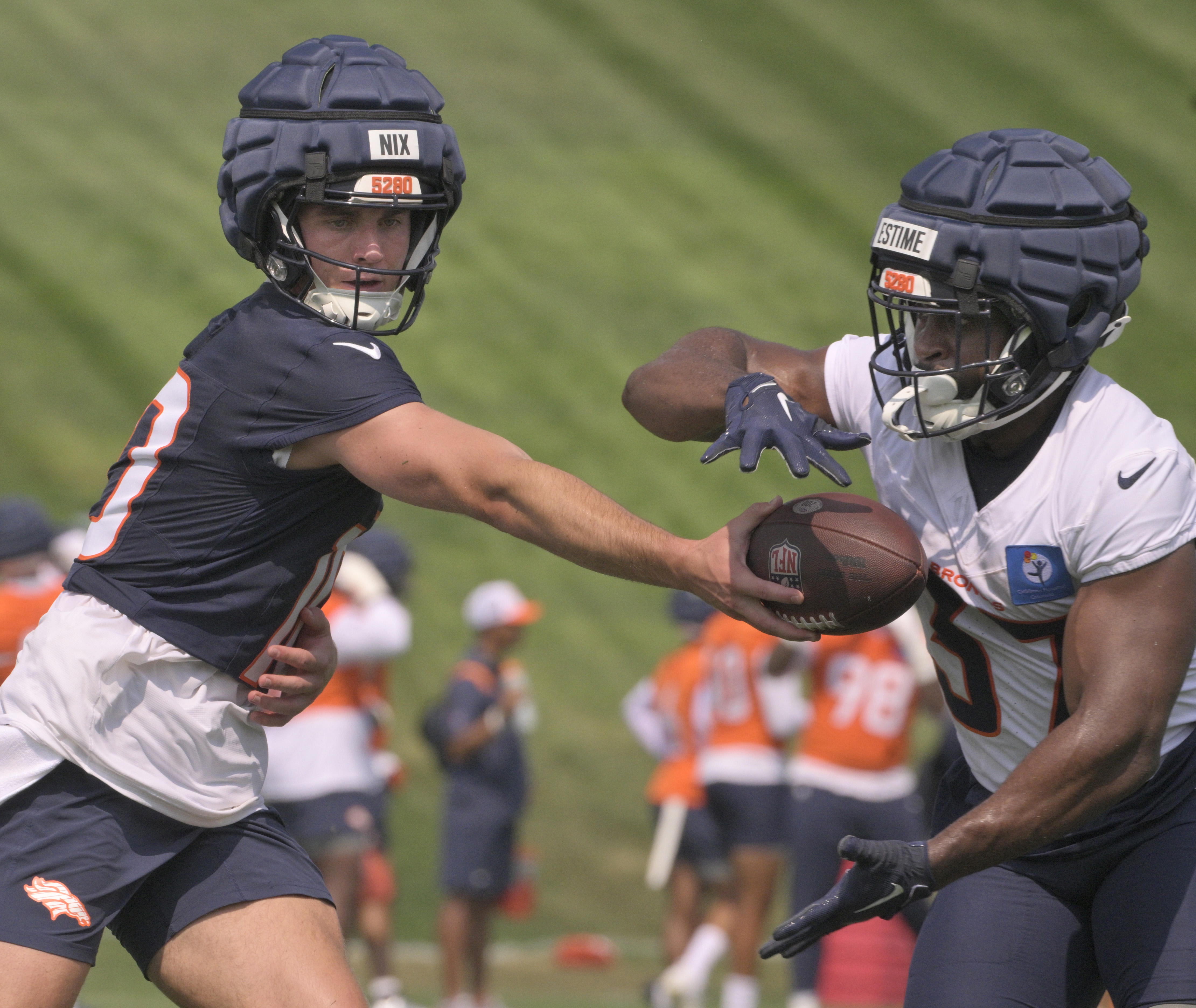Broncos quarterback Bo Nix hands off the ball to running back Audric Estime during practice at the Denver Broncos training center on Wednesday, July 24, 2024. (Jerilee Bennett The Gazette)