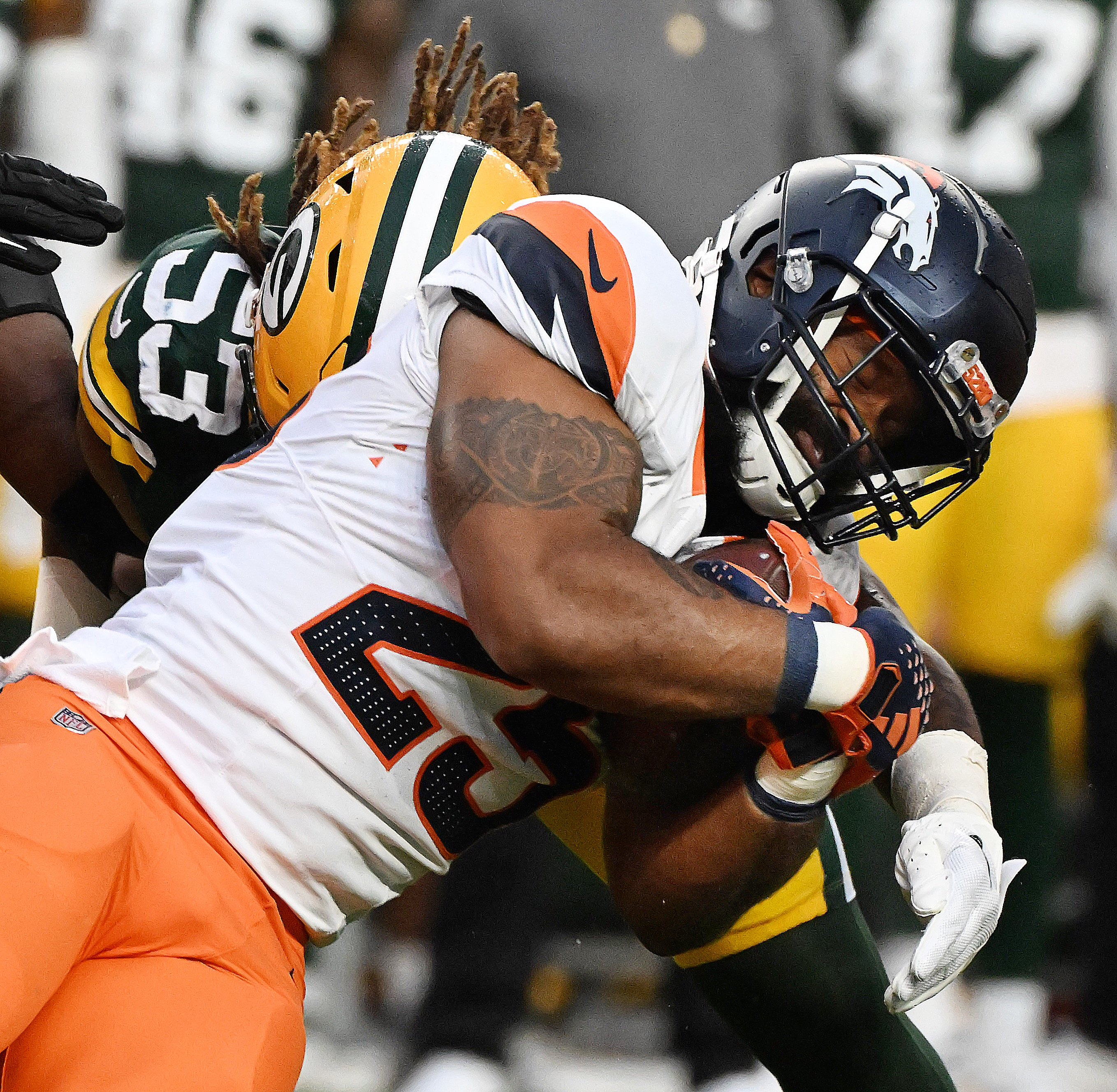 Denver Broncos running back Samaje Perine (25) tries to get past Green Bay Packers defensive end Arron Mosby (53) during a preseason game against the Packers on Sunday, Aug. 18, 2024. The Broncos won the game 27-2. (Jerilee Bennett, The Gazette)
