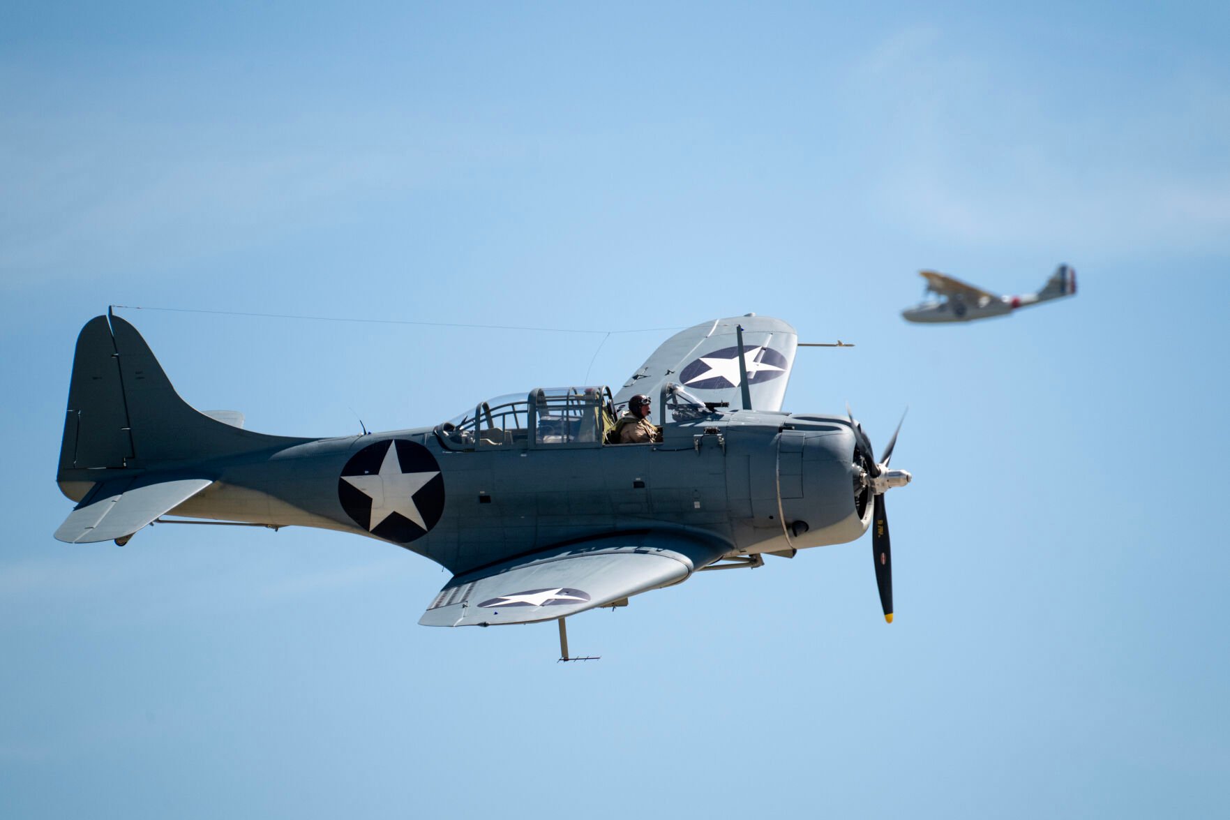 A Douglas SBD-4 Dauntless, front, and a Consolidated PBY/PBV-1A Catalina Patrol Bomber fly in the bomber parade at the Pikes Peak Regional Airshow at the Colorado Springs Airport on Saturday, Aug. 17, 2024. (Parker Seibold, The Gazette) (Parker Seibold, The Gazette)