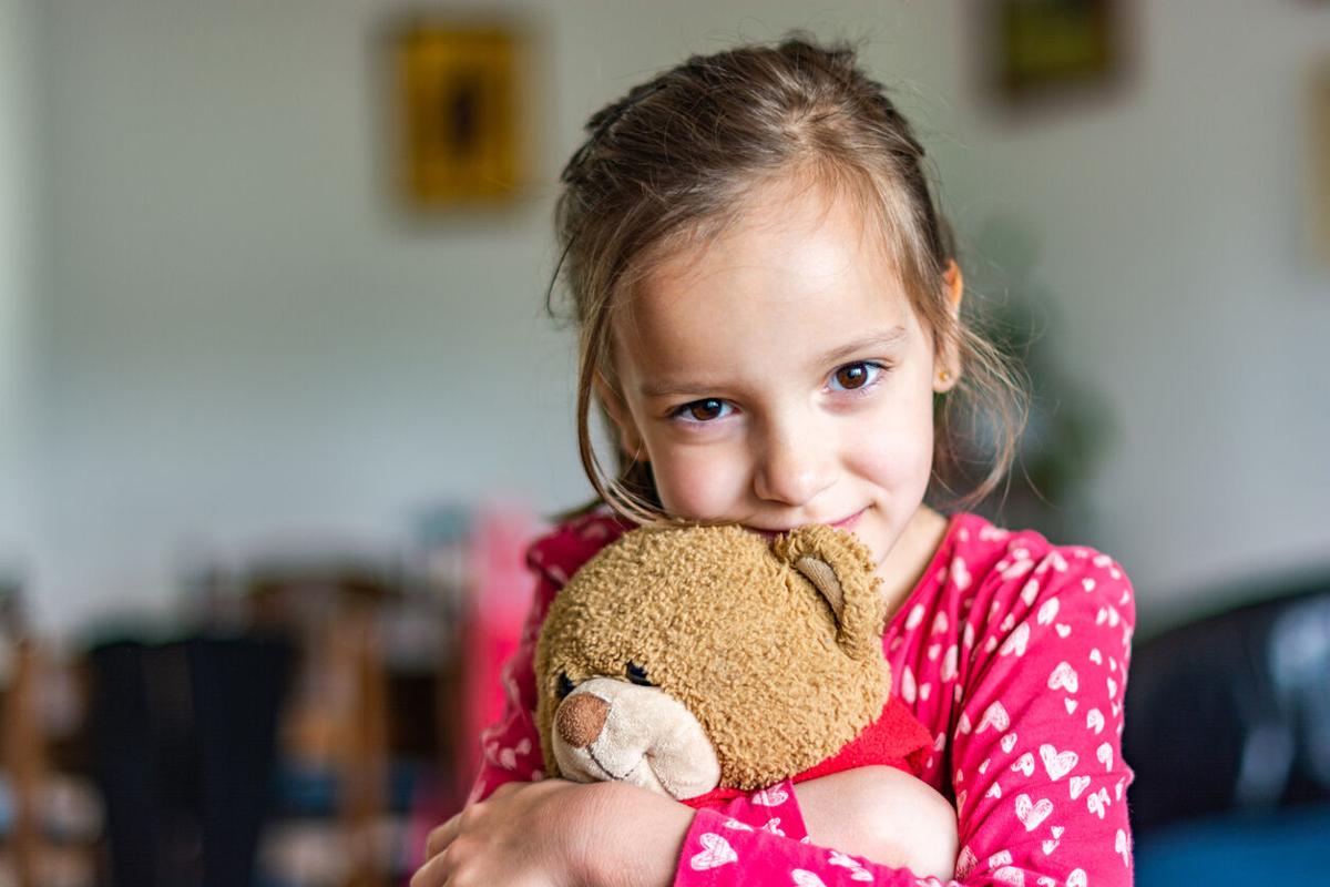Girl embracing teddy bear