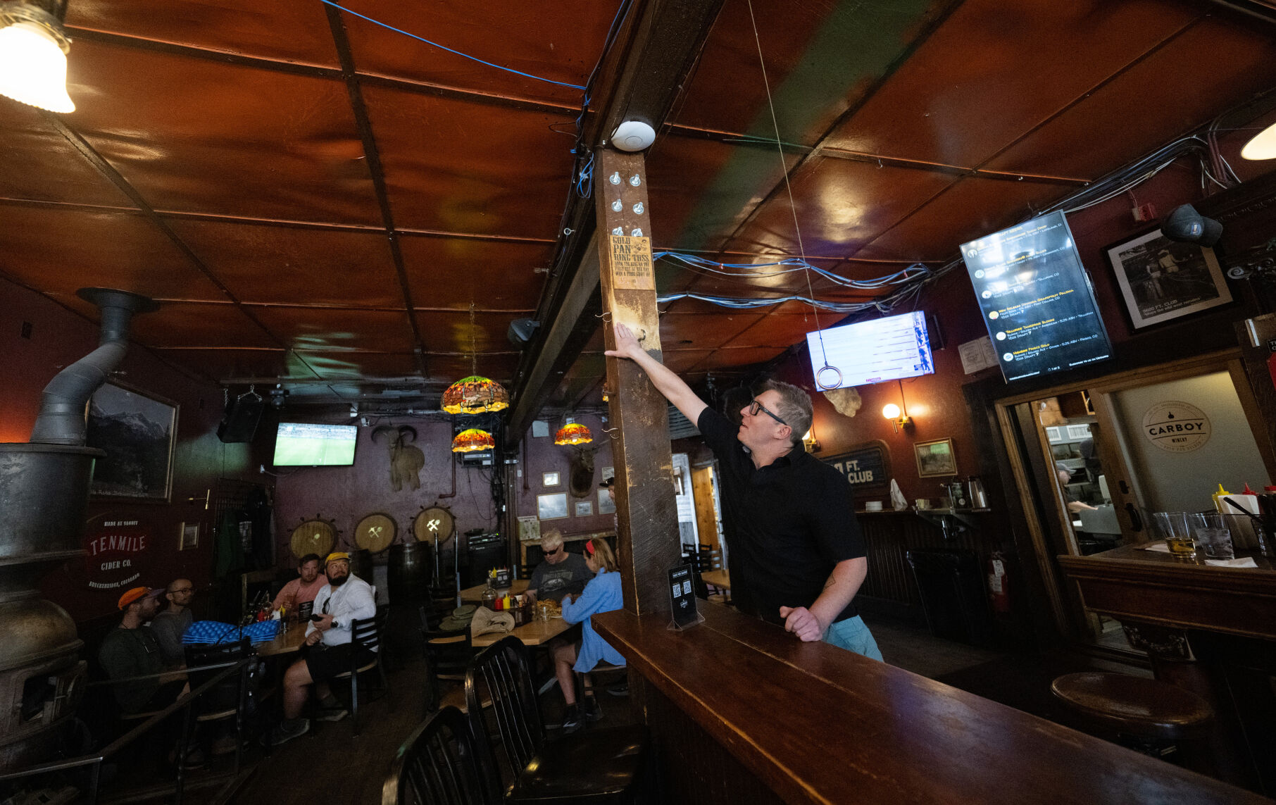 TOP: Aaron Corich-Kleim, part owner, shows the worn wooden post from nights of playing the Gold Pan ring toss at Breckenridge’s oldest bar, dating back to 1879. ABOVE: Garlic herb fries and the balsamic glazed ribs are served at the Gold Pan Saloon last month. (photos by Christian Murdock, The Gazette)