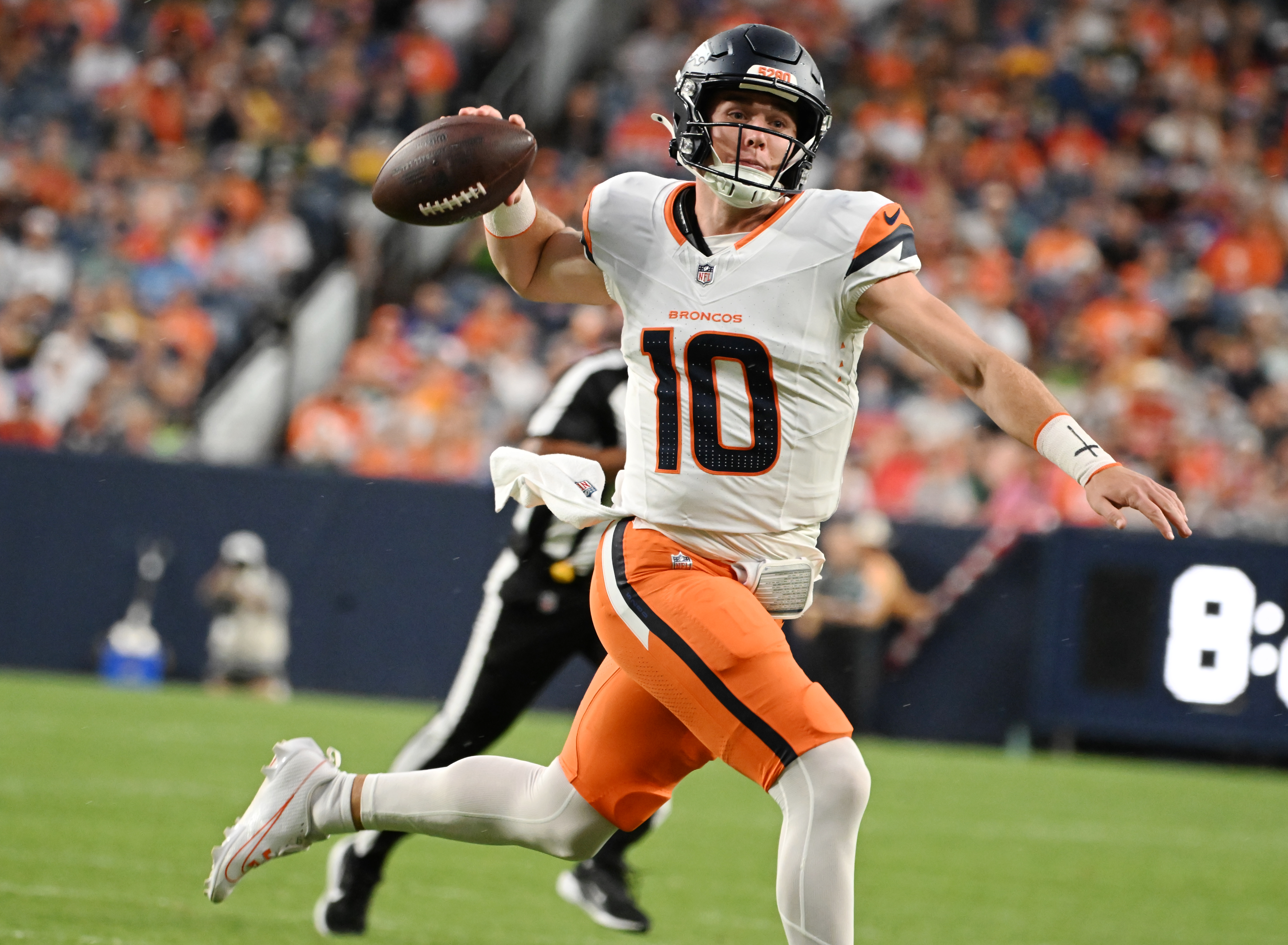 Broncos quarterback Bo Nix scrambles and throws the ball or a touchdown during the first quarter of a preseason game against the Packers on Sunday, Aug. 18, 2024. The touchdown was called back on a penalty. (Jerilee Bennett The Gazette)