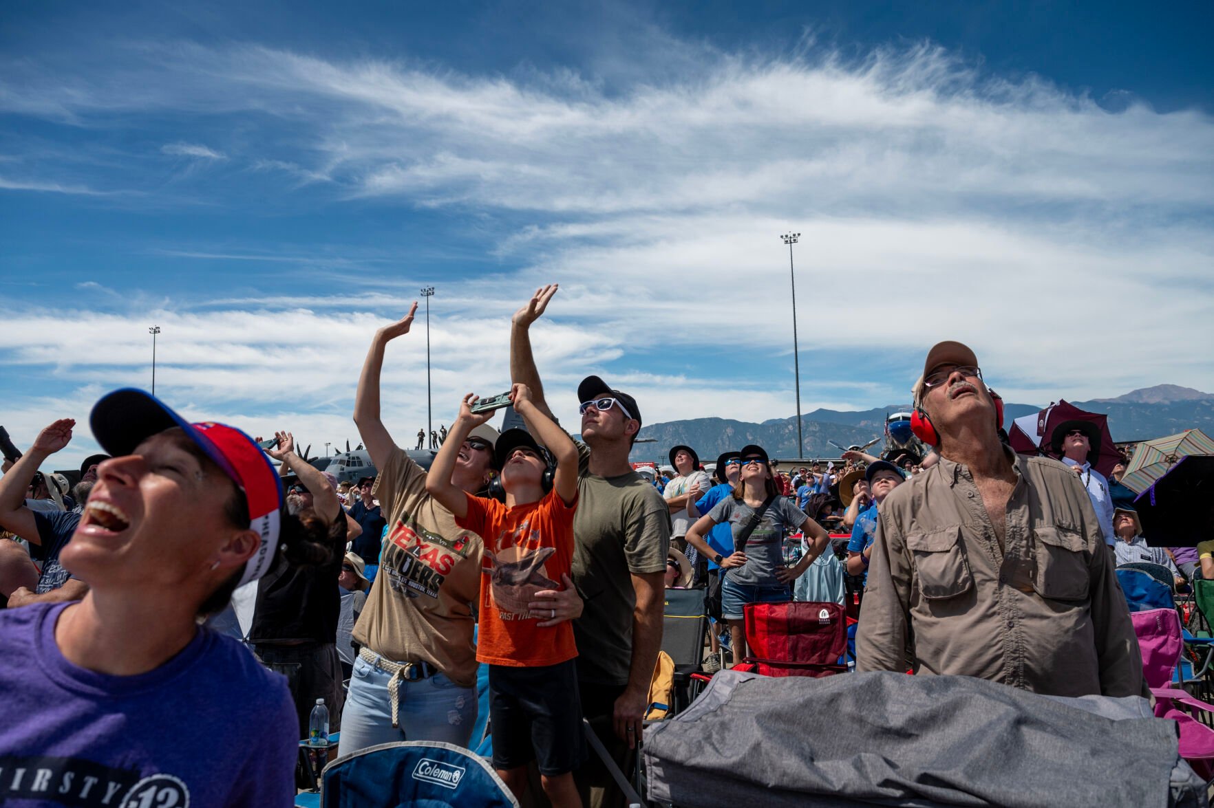 Eric Mitchell, Sarah Mitchell and their son Briggs look up to the sky to watch the Pikes Peak Regional Airshow at the Colorado Springs Airport on Saturday, Aug. 17, 2024. (Parker Seibold, The Gazette) (Parker Seibold The Gazette)