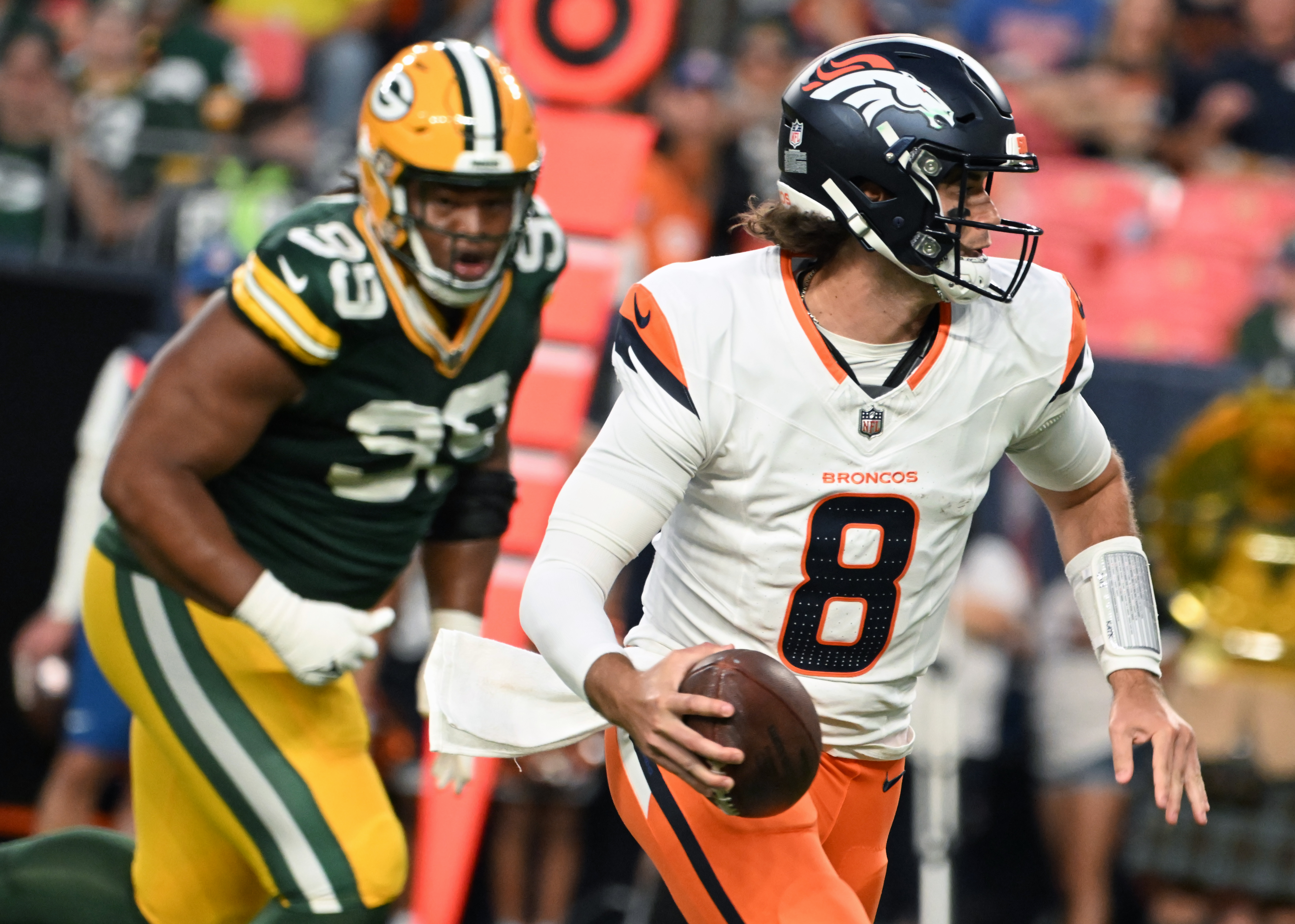 Broncos quarterback Jarrett Stidham scrambles with the ball or a touchdown during the second quarter of a preseason game against the Packers on Sunday, Aug. 18, 2024. (Jerilee Bennett The Gazette)