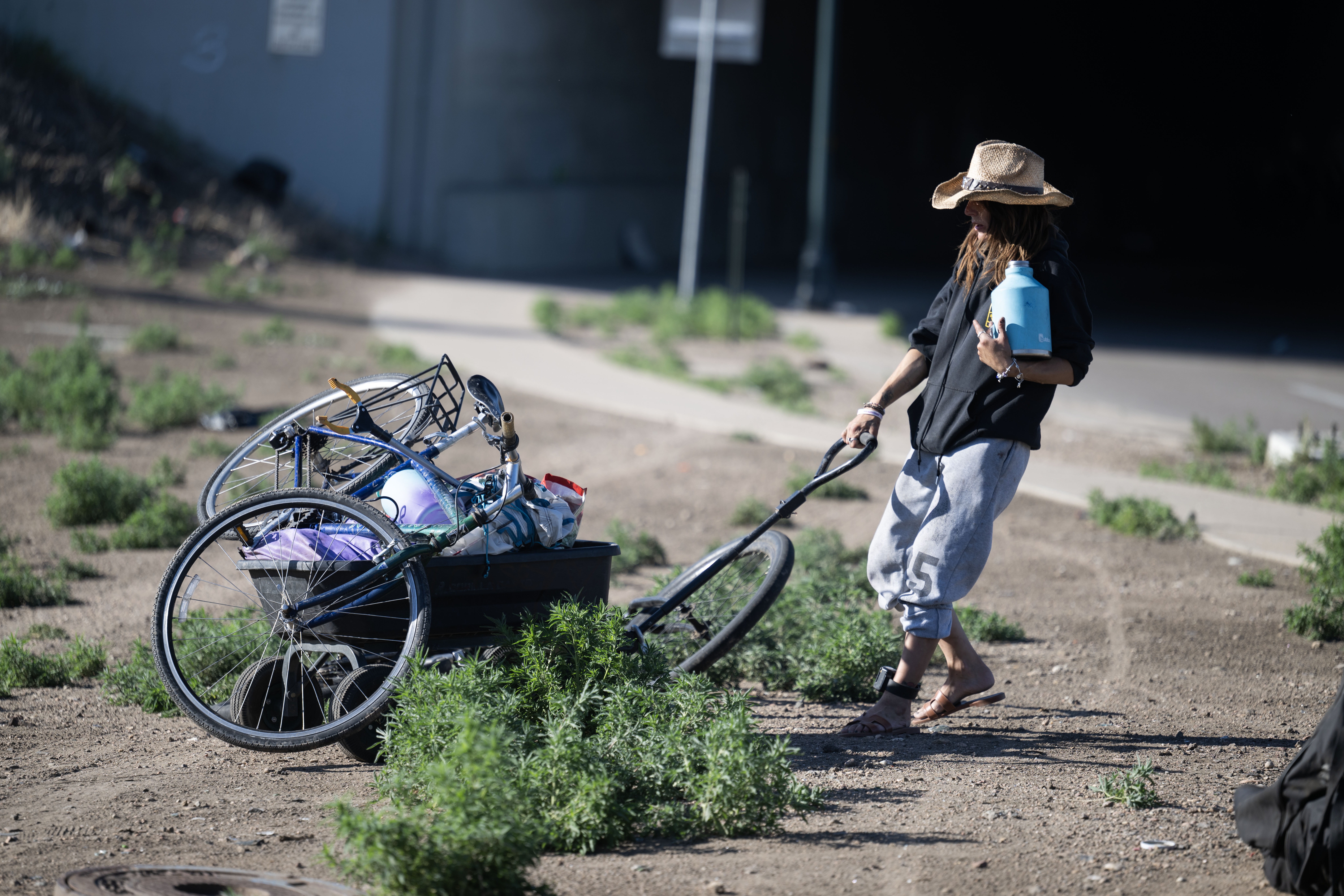 Casey Horn pulls a cart with her belongings from her camp to a nearby underpass as she and the other occupants rush to clear the area before a police sweep near 38th and Fox in Denver on Thursday, June 13, 2024. (StephenSwoffordPhotographerstephen.swofford@gazette.comhttps://secure.gravatar.com/avatar/1ddcaf11c5d70eaa58546ddc4e038687?d=mm&r=g)