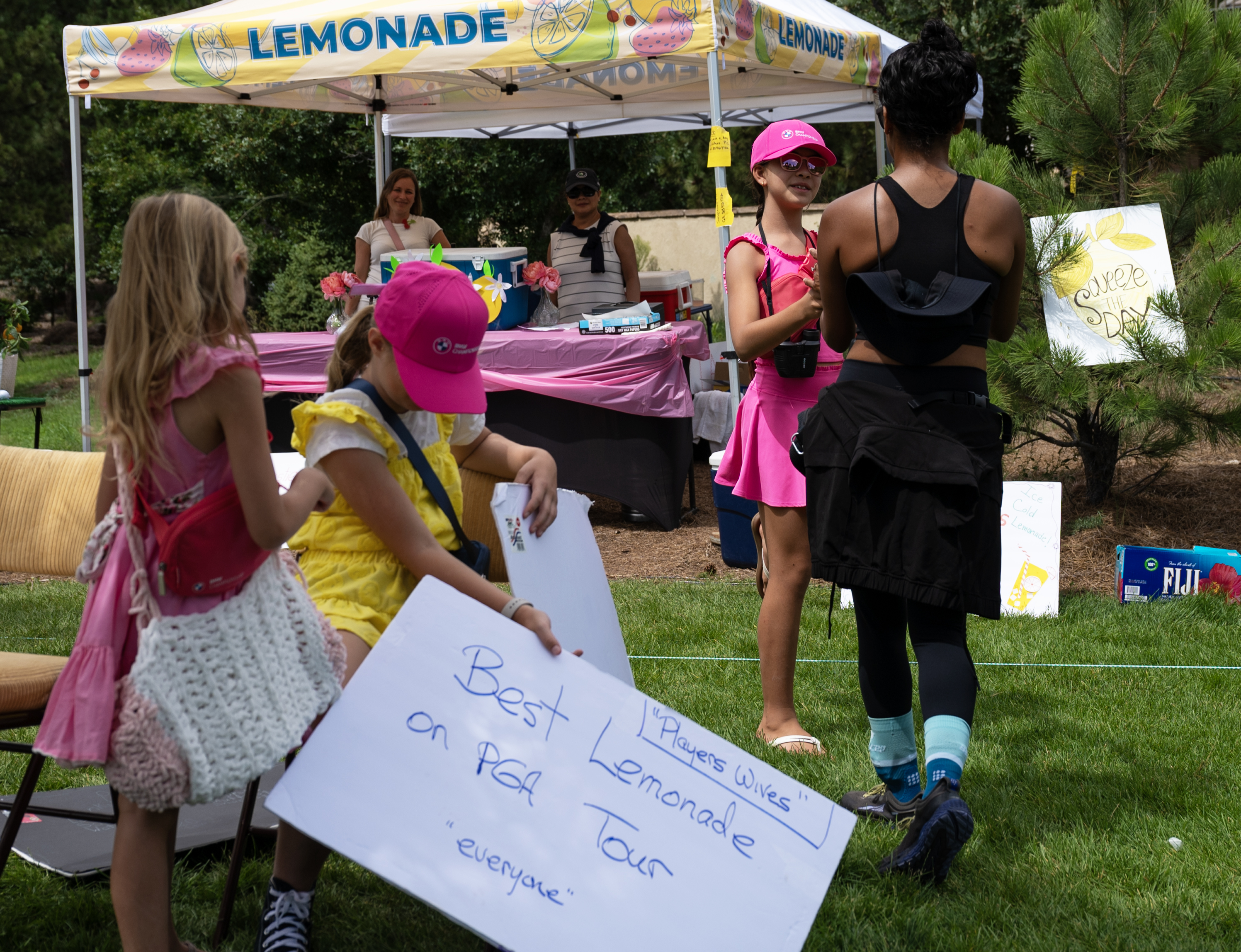 Grace Messner serves a customer lemonade from a lemonade stand just off the course during the third round of the BMW Championship at Castle Pines Golf Club, Saturday, Aug. 24, 2024, in Castle Rock, Colo. Messner and her friends Sophia, front right, and Hannah Gaudreault were selling lemonade, water, snacks and other goodies to passersby as they walked the course. (Parker Seibold, The Gazette) (Parker Seibold The Gazette)