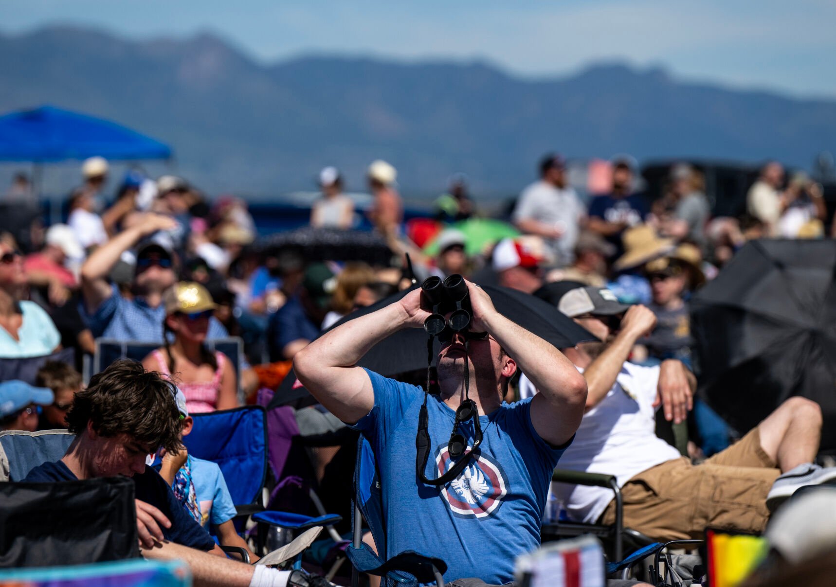 A spectator uses binoculars at the Pikes Peak Regional Airshow at the Colorado Springs Airport on Saturday, Aug. 17, 2024. (Parker Seibold, The Gazette) (Parker Seibold, The Gazette)