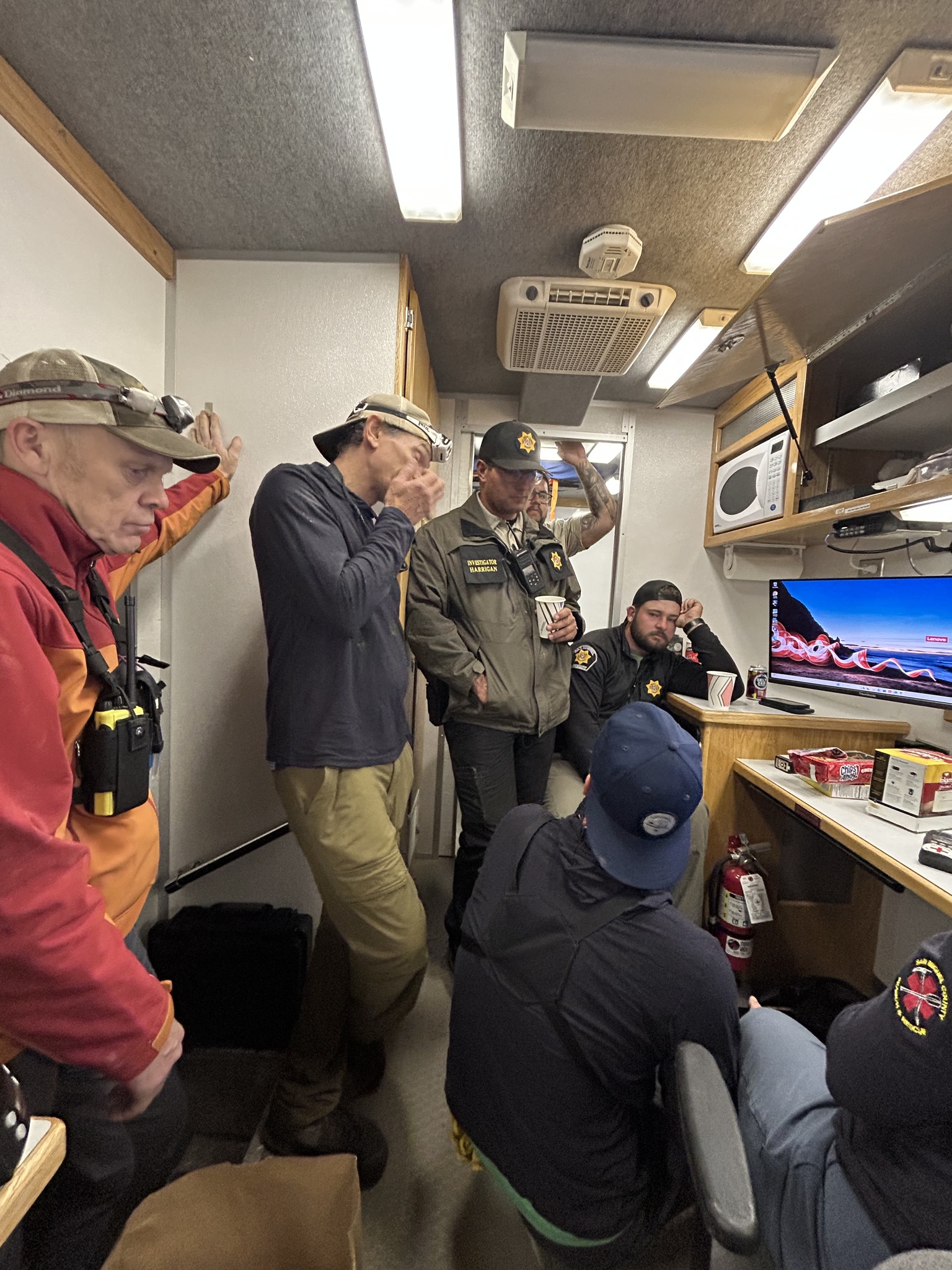 In a photo taken at the start of the multi-layered search, exhausted crews in head lamps and binoculars rode out the night in the Incident Command Post, a package of Chips Ahoy and coffee on a nearby table for fuel. (San Miguel County Sheriff)