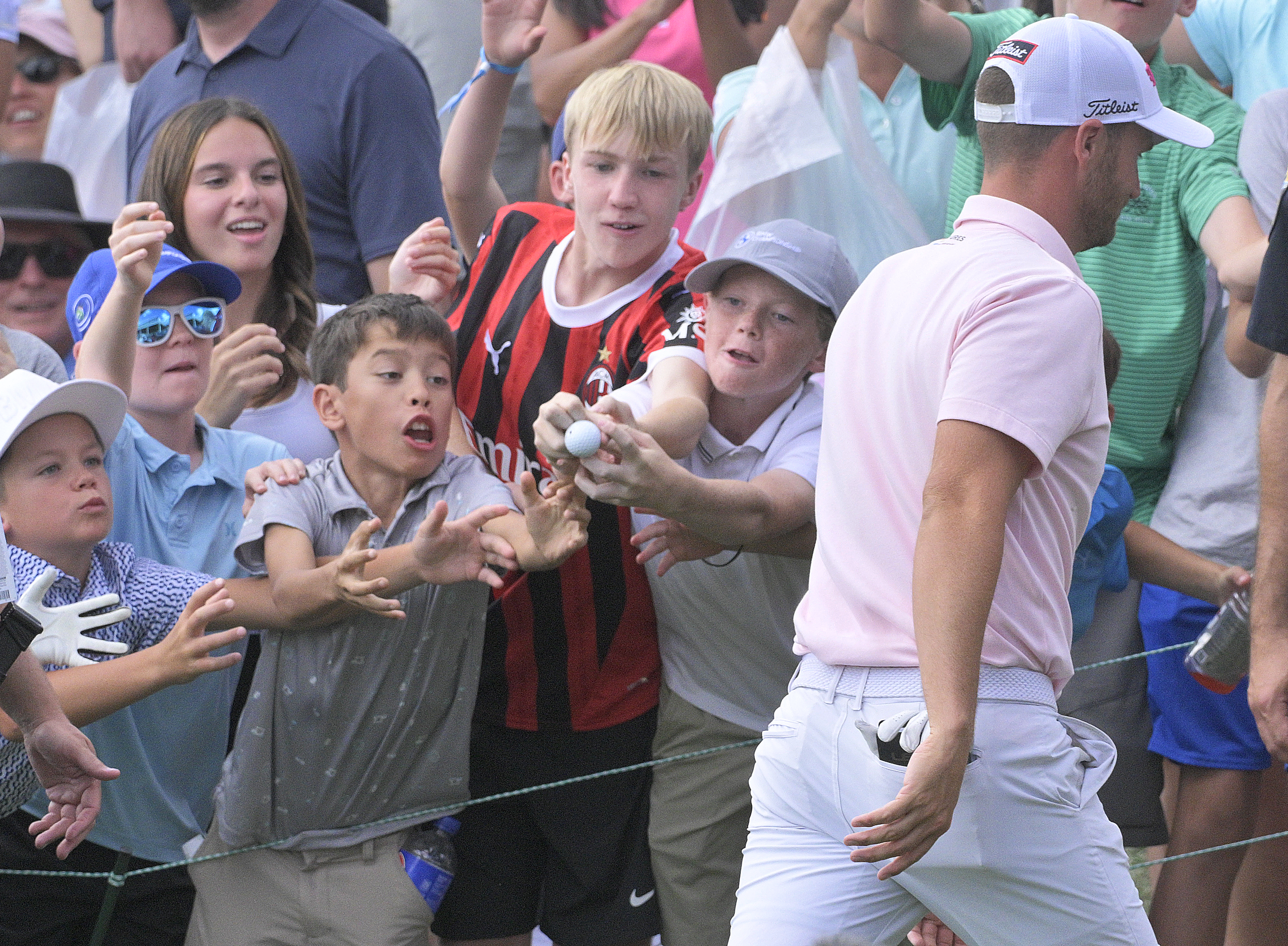 Wyndham Clark throws his golf ball to a group of happy kids after he finishes at the BMW Championship on Sunday, August 25, 2024.