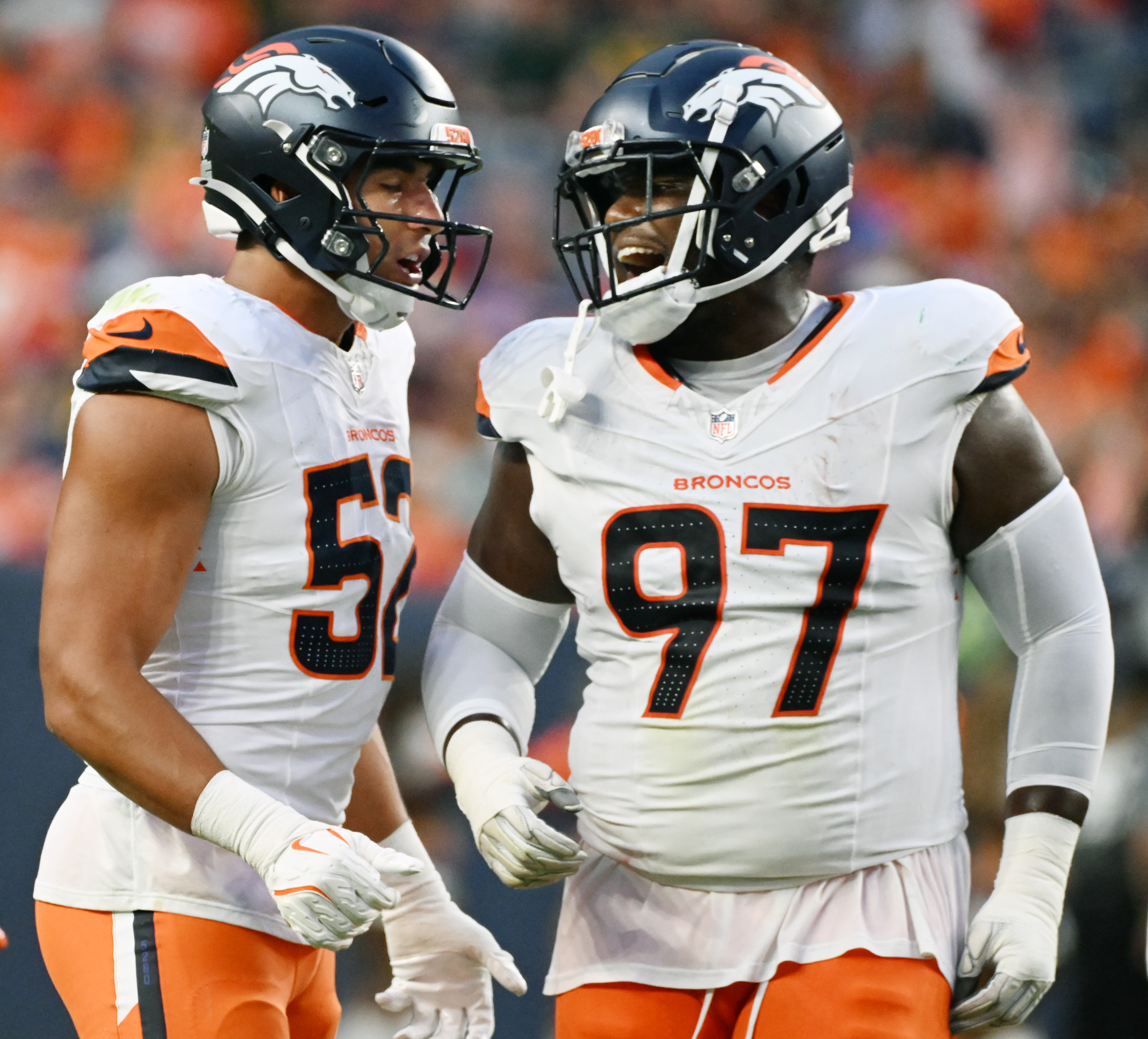 Denver Broncos linebacker Jonah Elliss (52) and Denver Broncos defensive tackle Malcolm Roach (97) joke around during a preseason game against the Packers on Sunday, Aug. 18, 2024. The Broncos won the game 27-2. (Jerilee Bennett, The Gazette)
