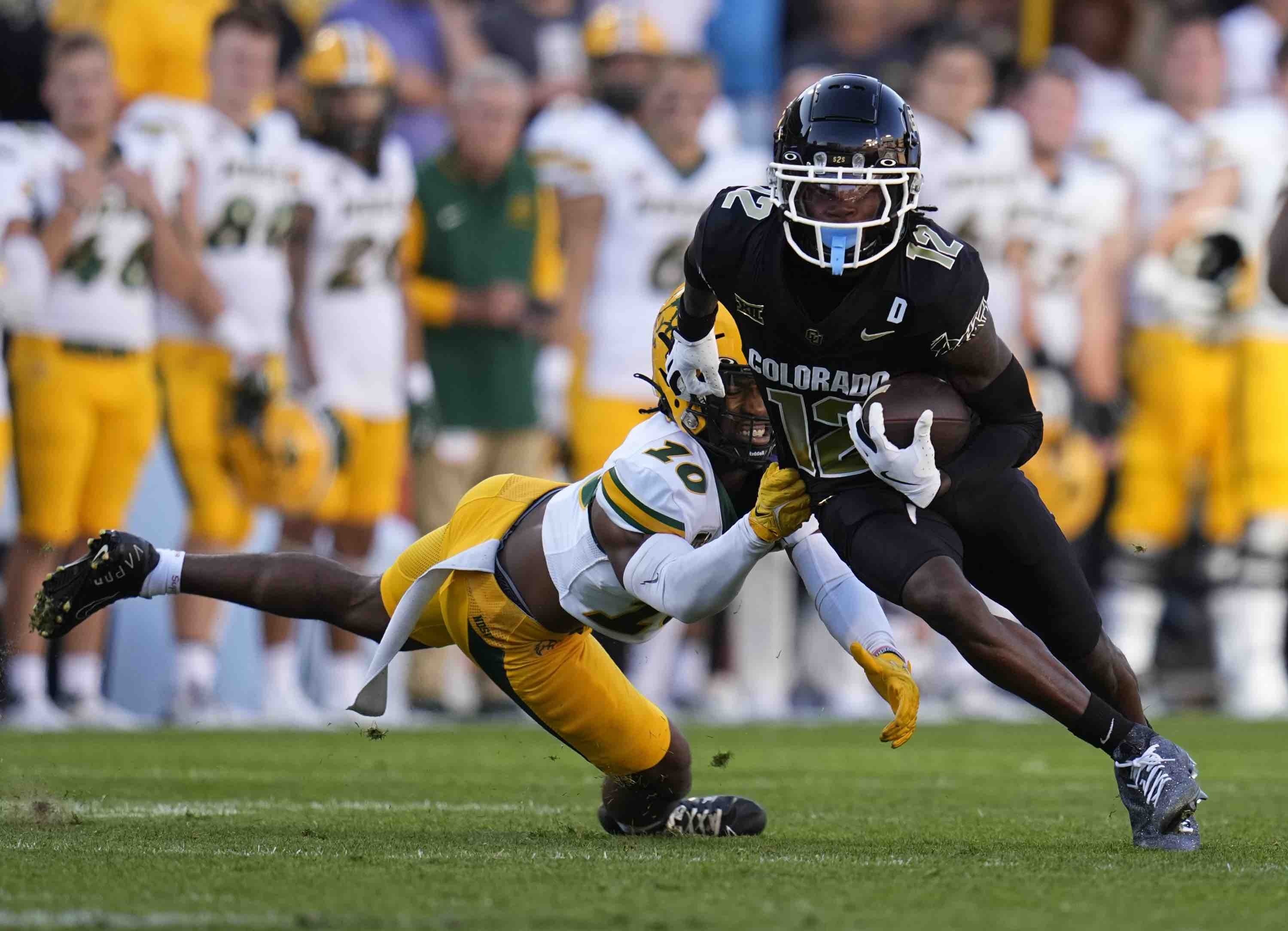 Colorado receiver Travis Hunter (12) shakes a tackle against North Dakota State cornerback Marcus Sheppard (10) for a touchdown during the first half of an NCAA college football game Thursday, Aug. 29, 2024, in Boulder, Colo. (AP Photo/Jack Dempsey) (Jack Dempsey)