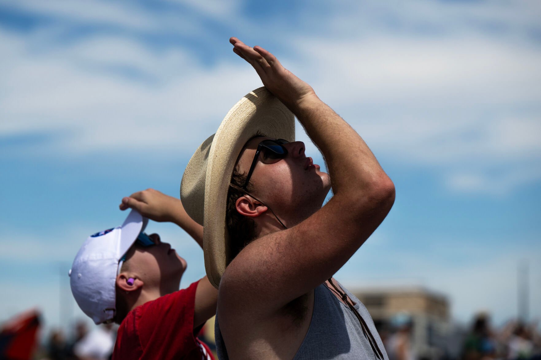 Spectators use their hands to shade their faces as they watch the Pikes Peak Regional Airshow at the Colorado Springs Airport on Saturday, Aug. 17, 2024. (Parker Seibold, The Gazette) (Parker Seibold, The Gazette)