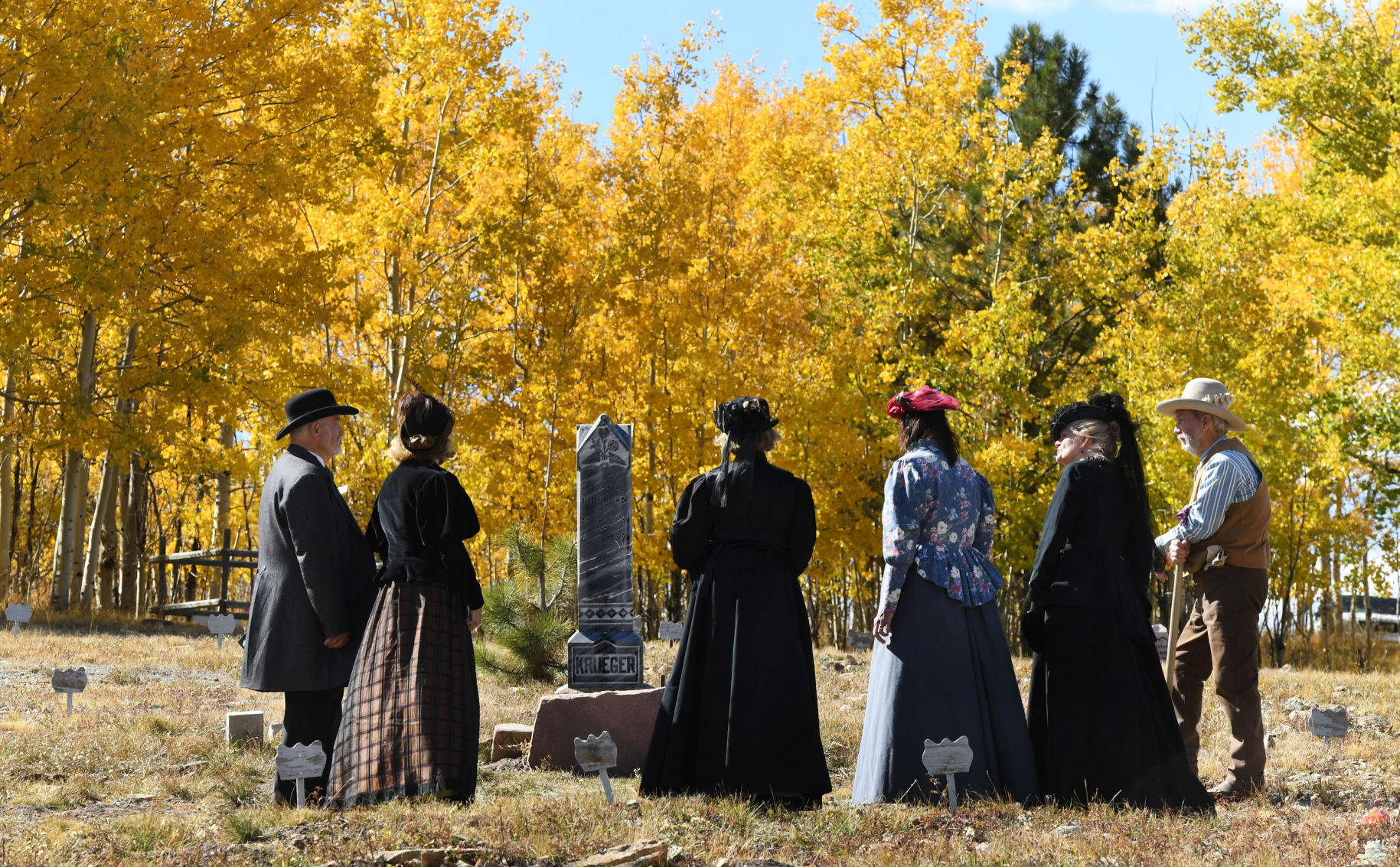 Members of the Gold Camp Victorian Society gather around a headstone amid a backdrop of vibrant fall colors during a tour of the Mount Pisgah Cemetery near Cripple Creek in this Courier file photo. The aspens are changing, providing spectacular scenery in Teller County and around Colorado. Story, page 8 (Jerilee Bennett, PIKES PEAK COURIER)