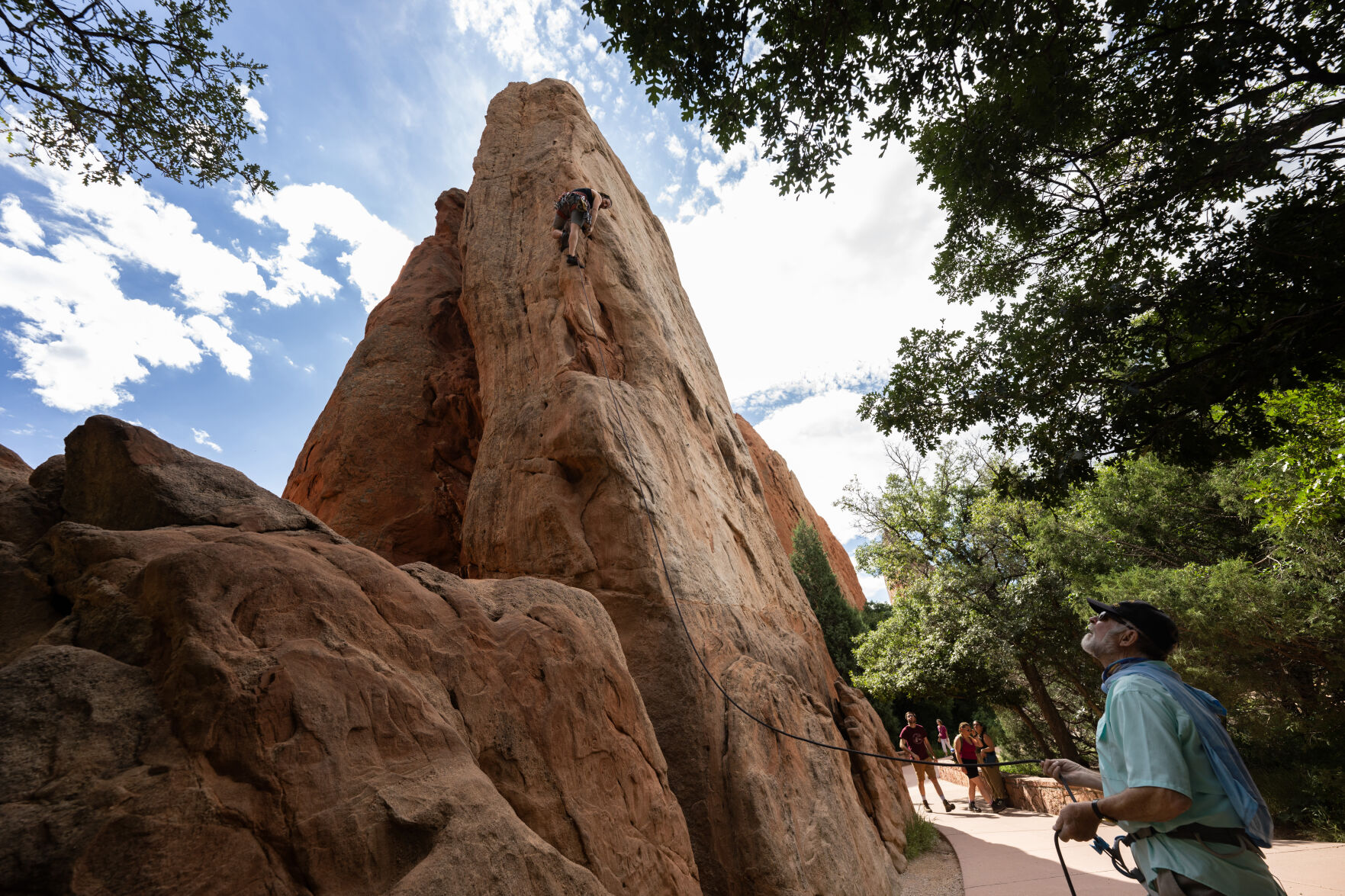ABOVE: Craig Richard, 40, climbs in Garden of the Gods Park as his father, Ron Smith, 78, belays Aug. 22. BELOW: Richard puts on the climbing shoes his father handed down to him when he was 13. (photos by Christian Murdock, The Gazette)