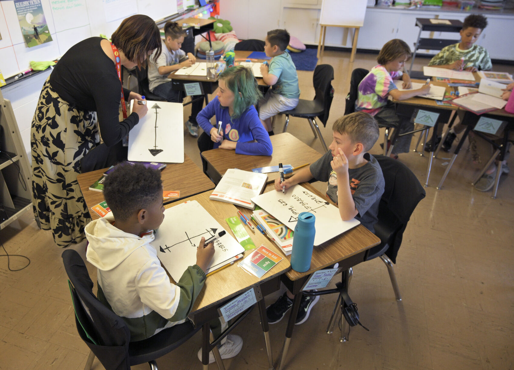 Fourth grade teacher Karina Hoppner works with her students in their teams on some math problems Thursday at Audubon Elementary School. (The denver Gazette)