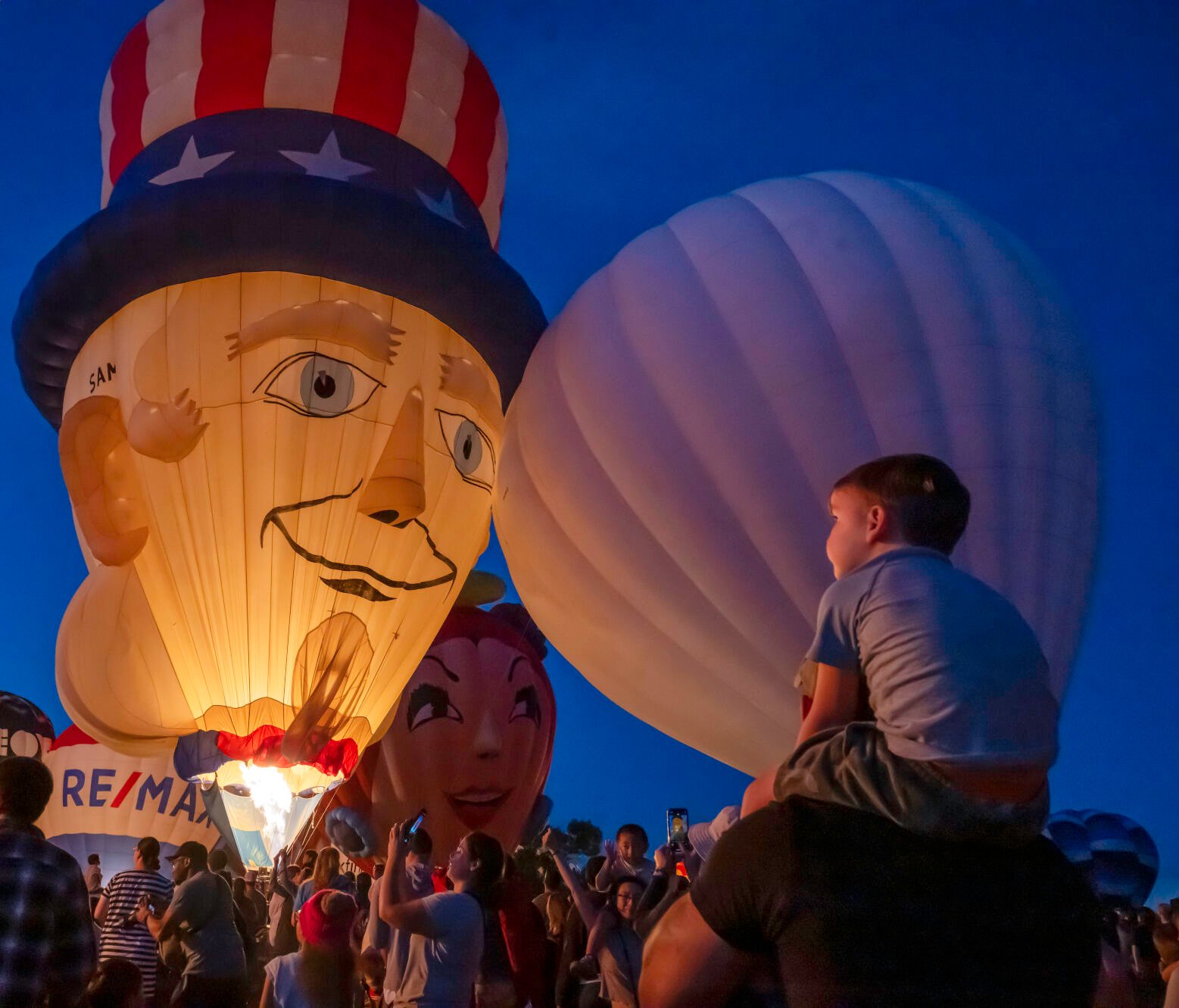 The Uncle Sam balloon looks down over a massive crowd during a balloon glow evening of the Colorado Springs Labor Day Lift Off on Sunday, Sept. 1, 2024.
