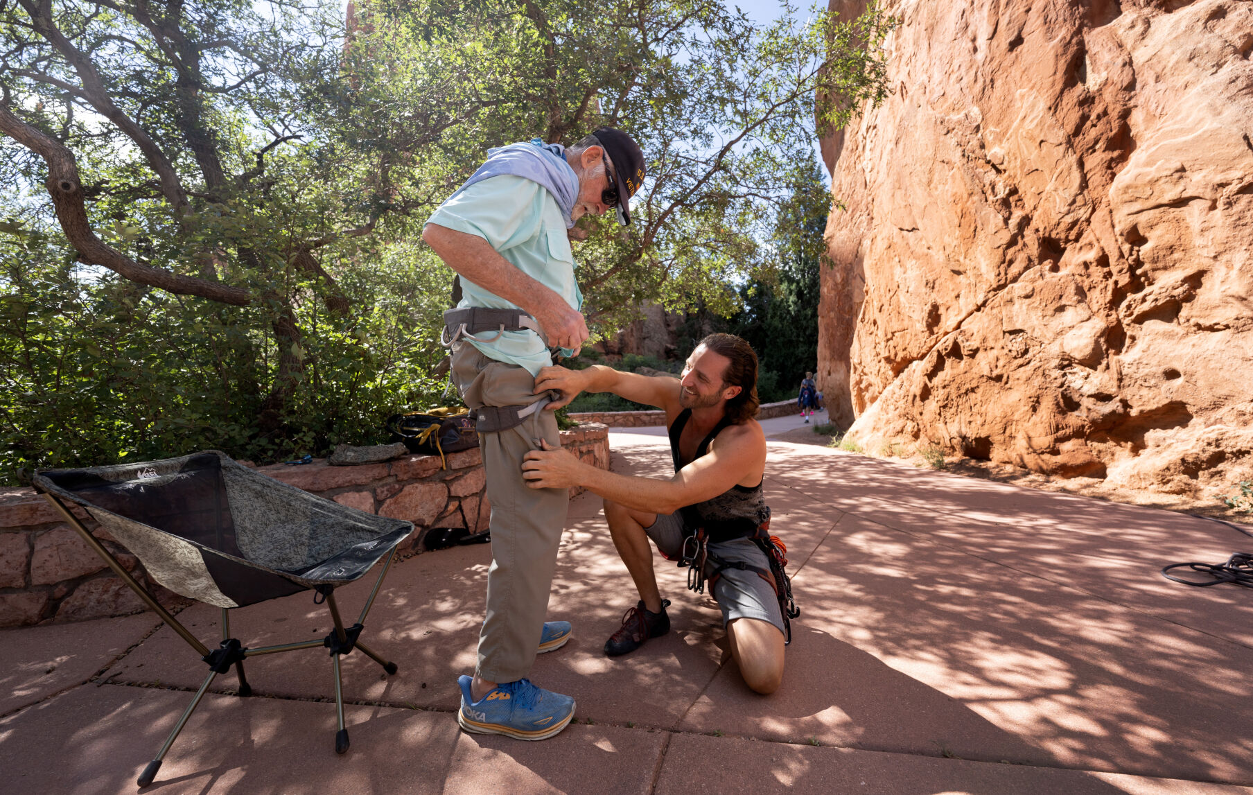 Craig Richard helps his father, Ron Smith, with his climbing harness before Smith belayed for Richard Thursday, Aug. 22, 2024, in Garden of the Gods Park where they both learned to climb as young children. (The Gazette, Christian Murdock) (Christian Murdock, The Gazette)