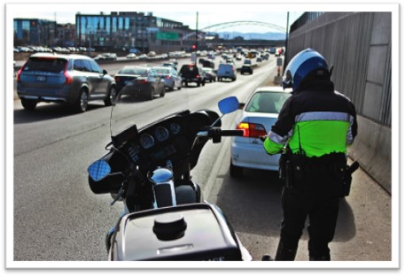 A Denver police officer pulling a vehicle over on Interstate 25. For the week of Sept. 23, the department will increase its enforcement over expired license plate tags in a effort to increase license plate renewals among drivers. (Courtesy photo, Denver Police Department)
