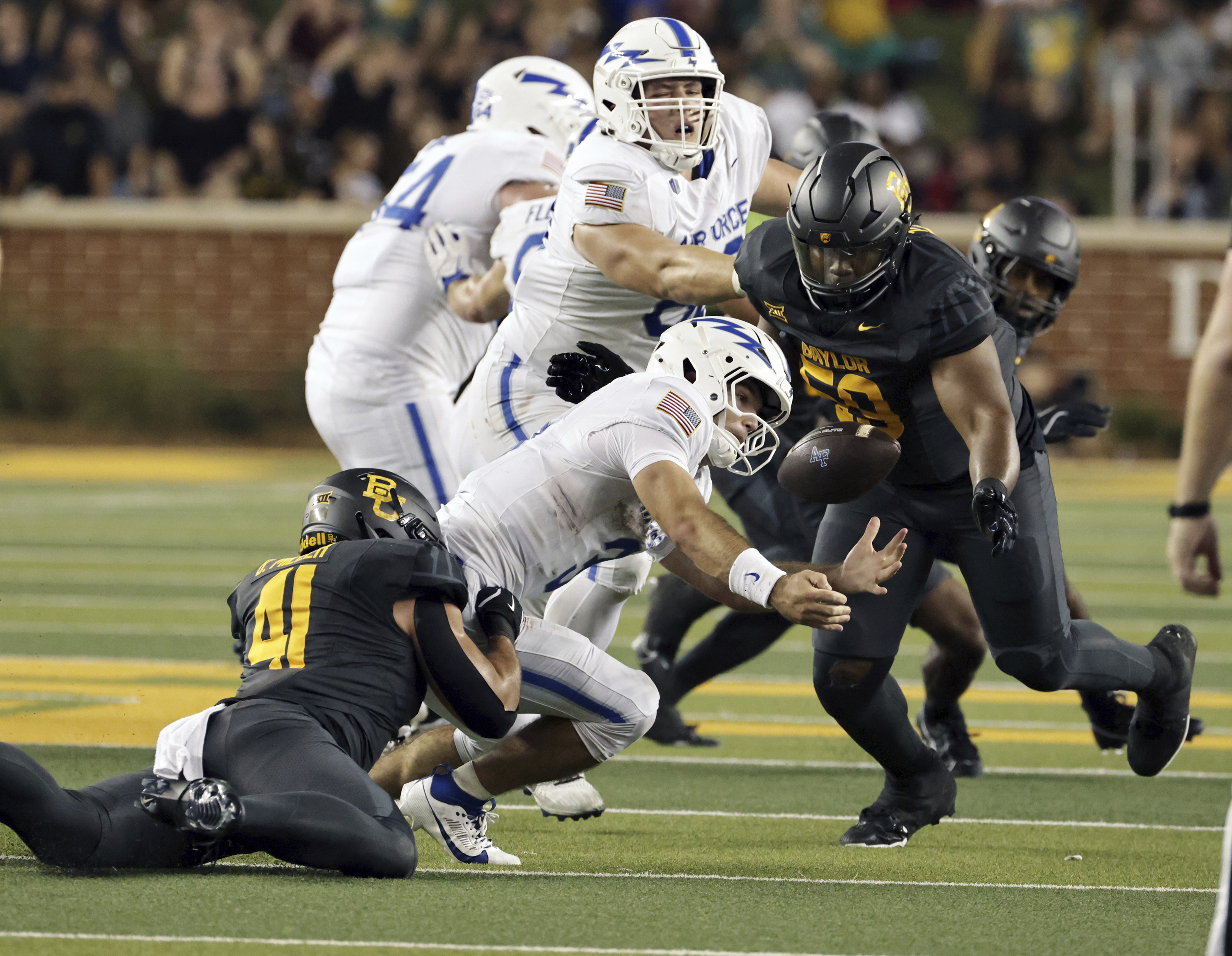 Air Force's John Busha, center bottom, fumbles after getting hit by Baylor linebacker Brooks Miller (41) in the second half of an NCAA college football game, Saturday, Sept. 14, 2024, in Waco, Texas. (Rod Aydelotte/Waco Tribune-Herald, via AP) (Jerry Larson)
