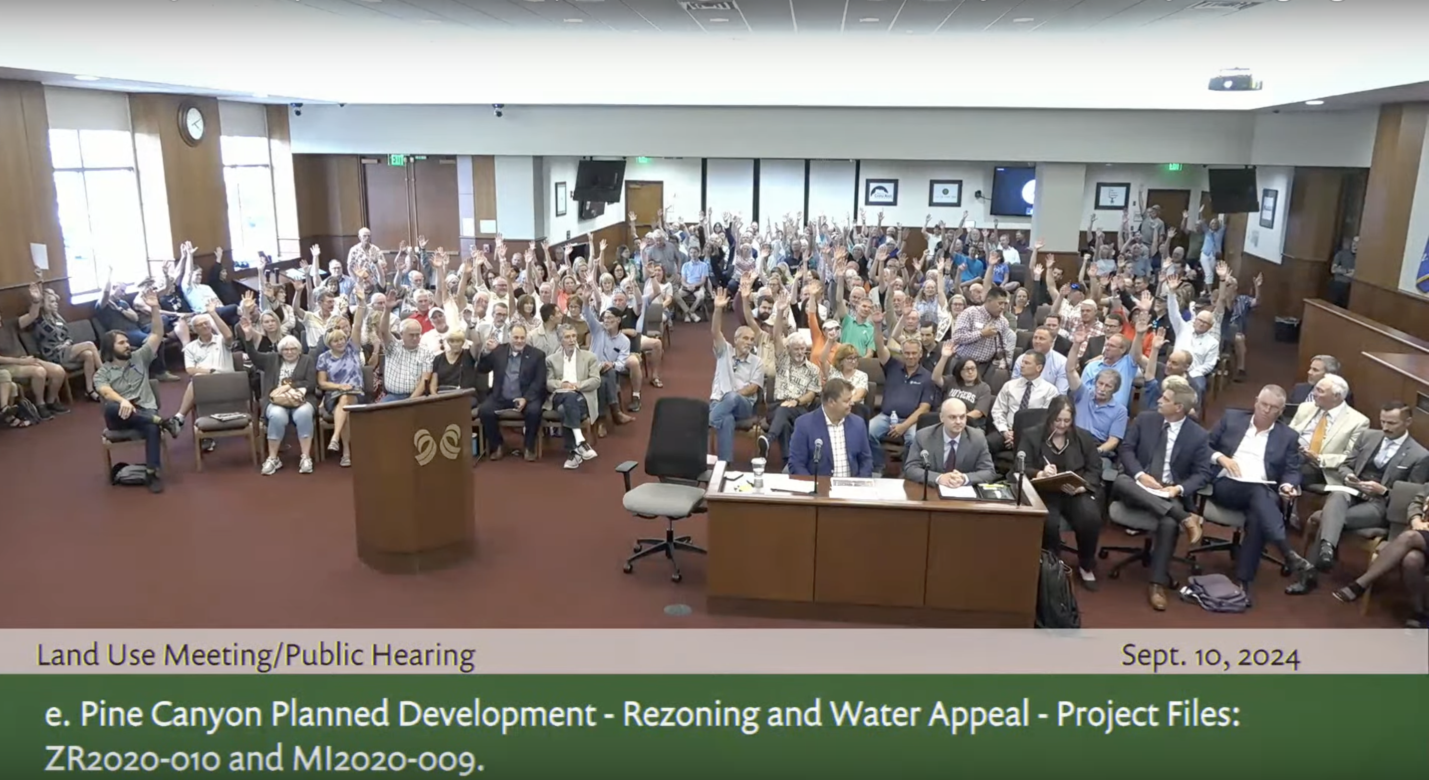FILE PHOTO: Dozens of Douglas County residents raise their hand when asked who opposed a proposed 530-acre redevelopment of Pine Canyon in unincorporated land splitting Castle Rock. Many residents and elected officials spoke in opposition of the proposal on Tuesday, Sept. 10 at the Douglas County Building in Castle Rock, Colorado. (Screengrab from Douglas County Board of Commissioners Land Use meeting.)
