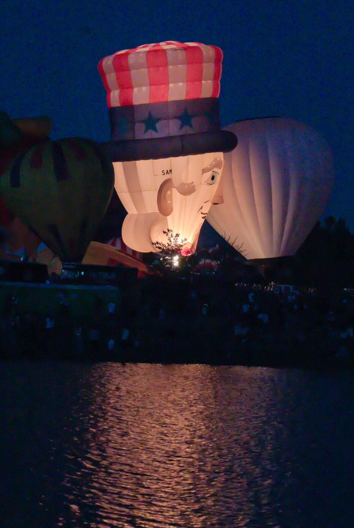 The Uncle Sam balloon reflects in Prospect Lake during a balloon glow evening of the Colorado Springs Labor Day Lift Off on Sunday, Sept. 1, 2024.