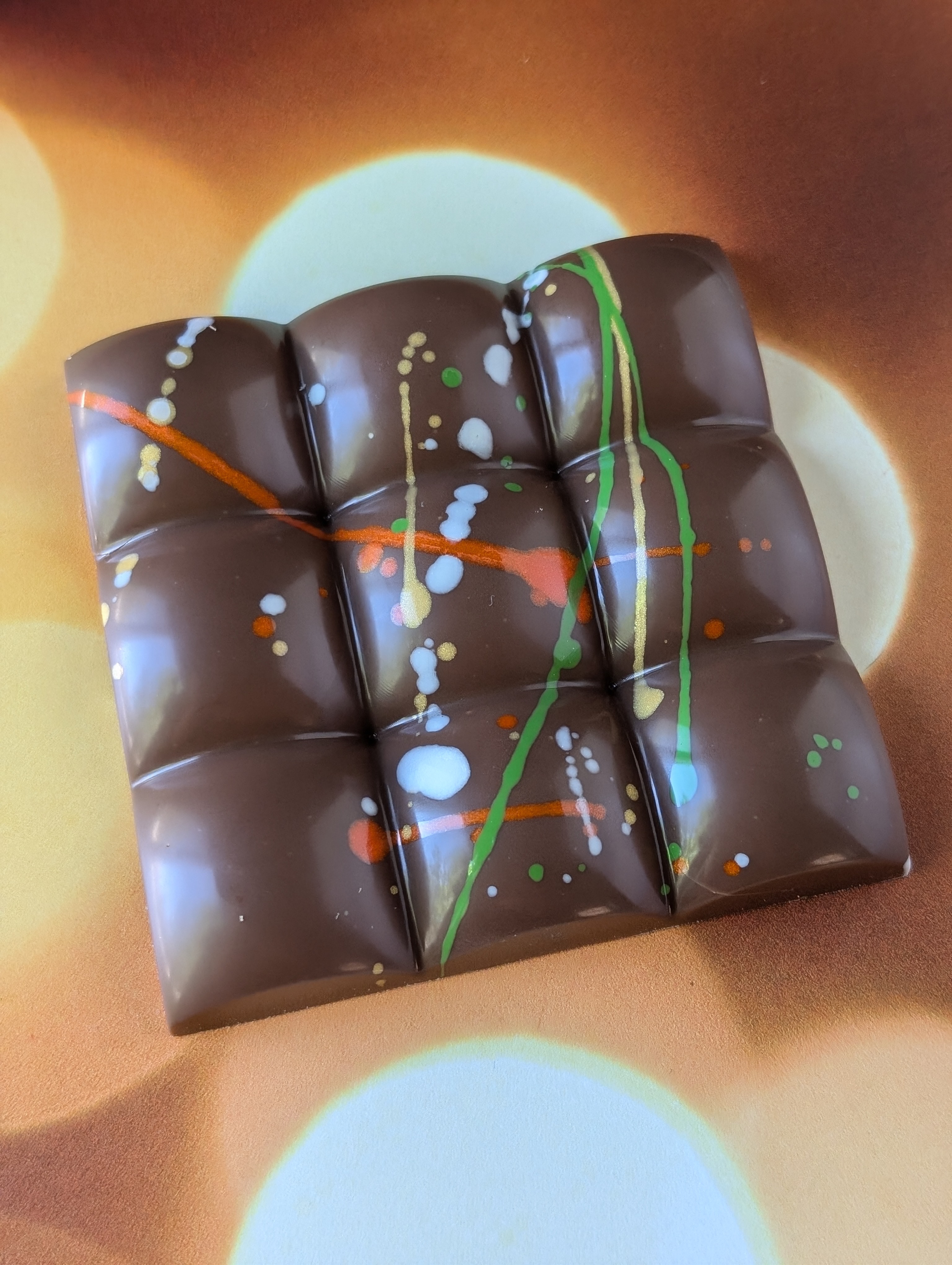 A close-up of Colorado Cocoa Pod’s Dubai Chocolate Bar, featuring a colorful, artistic design. Made with both milk and dark chocolate options, this dessert is popular for its bold flavors and unique textures, all crafted from ethically sourced ingredients. (Courtesy: Colorado Cocoa Pod)