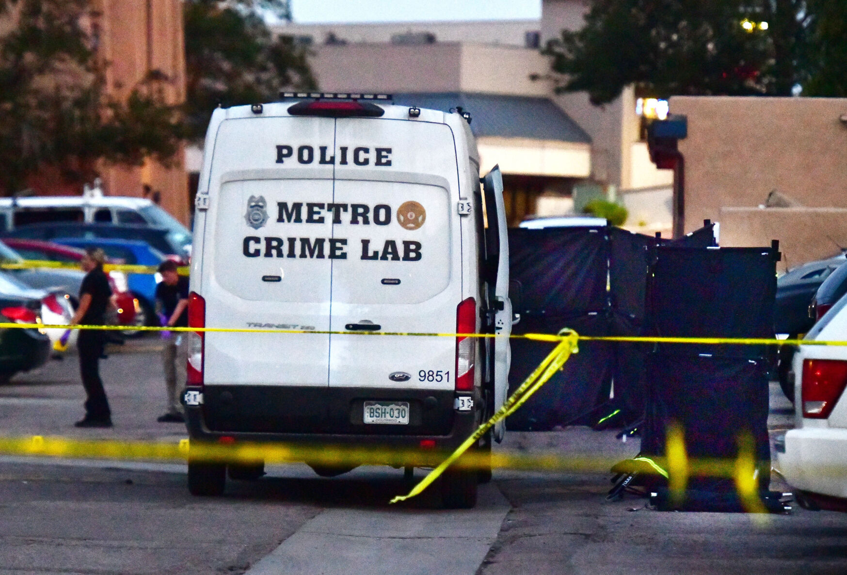 This file photo shows the scene where a juvenile was shot and killed in the parking lot of an apartment complex in 2020. Black crime partitions were put up around the body of the victim next to the crime lab van during the investigation. (THE DENVER GAZETTE FILE)