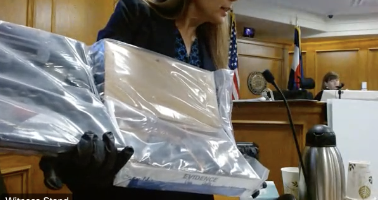 FBI Special Agent Stephanie Benitez showed the jury in the Boulder mass shooting trial a plastic-wrapped package which contains the SAR pistol investigators found in the alleged gunman's bedroom closet in the early hours of March 23, 2021, after the incident. Investigators also found an AR pistol, multiple loaded magazines, receipts for firearms and potential bomb-making materials. (Screengrab of 20th Judicial District WebEx live feed)