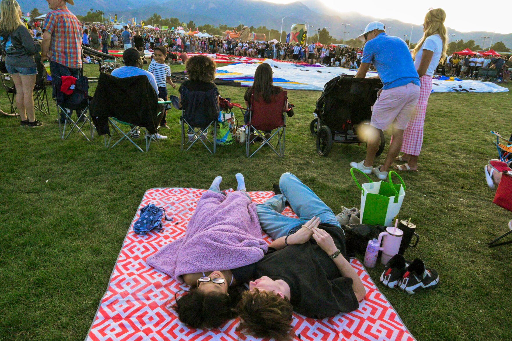A couple gets comfy at a ringside seat of the balloon glow of the Colorado Springs Labor Day Lift Off on Sunday, Sept. 1, 2024.