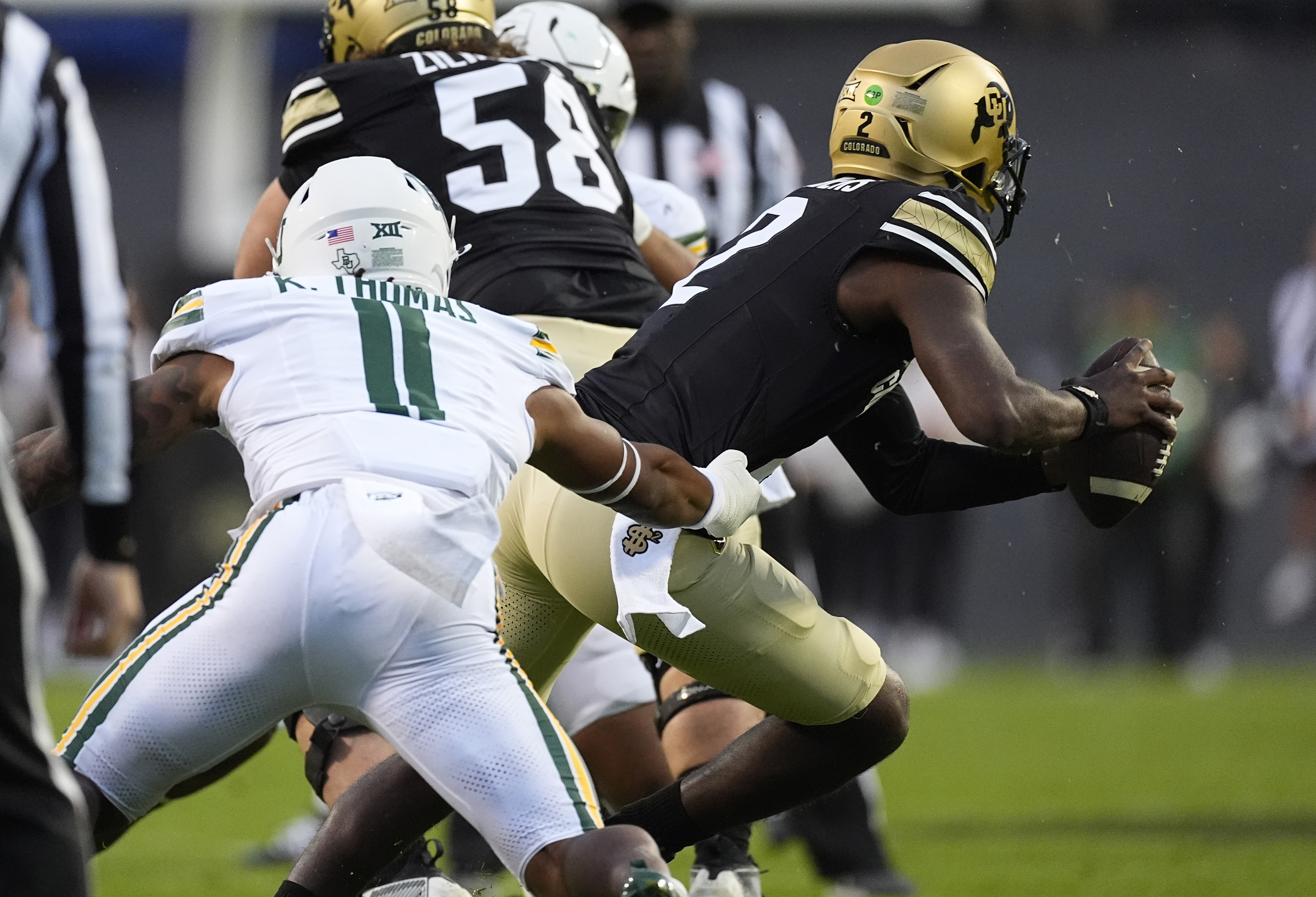 Baylor linebacker Keaton Thomas, left, pursues Colorado quarterback Shedeur Sanders, right, in the first half of an NCAA college football game Saturday, Sept. 21, 2024, in Boulder, Colo. (AP Photo/David Zalubowski) (David Zalubowski)