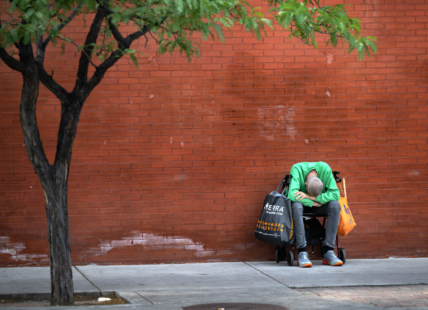 A man sleeps on a sidewalk in downtown Colorado Springs on Friday. (Christian Murdock, the gazette)